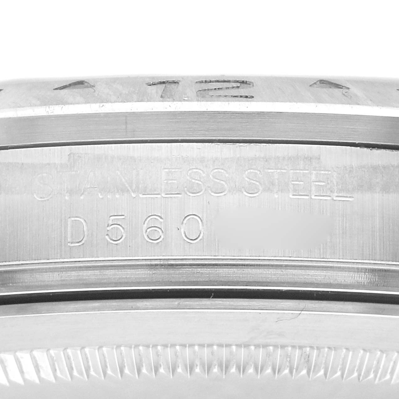 The image shows a close-up of the side of a Rolex Explorer model 16570, highlighting the stainless steel material and partial serial number engraving.