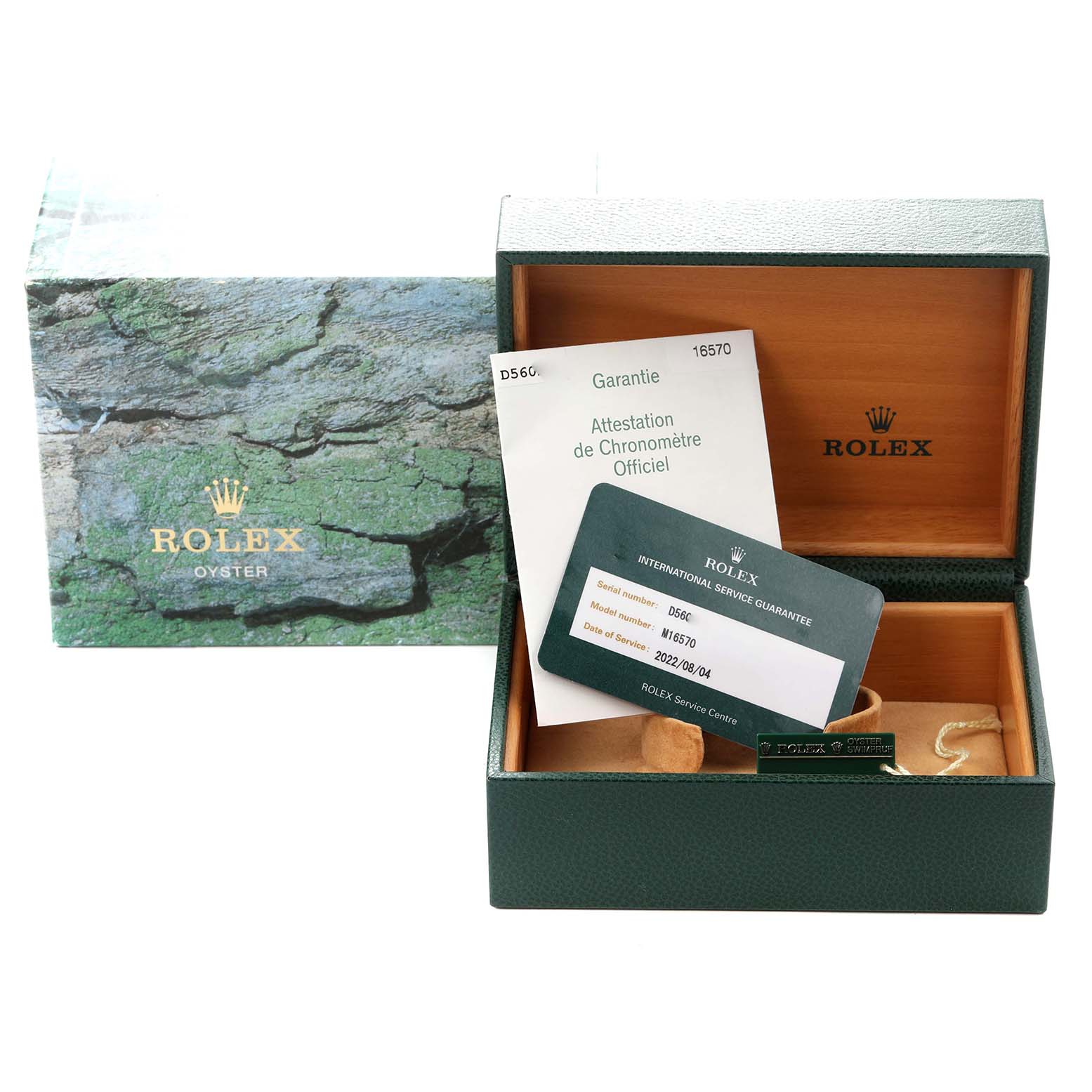 The image shows an open Rolex box for the Explorer model, model number 16570, with accompanying warranty cards and paperwork.