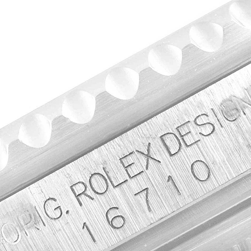 This close-up image shows the edge of the bezel and the engraved text "ORIG. ROLEX DESIGN 16710" on the Rolex GMT-Master 16710 Men
s Stainless Steel Black Dial 16710 Men
s Stainless Steel Black Dial watch.