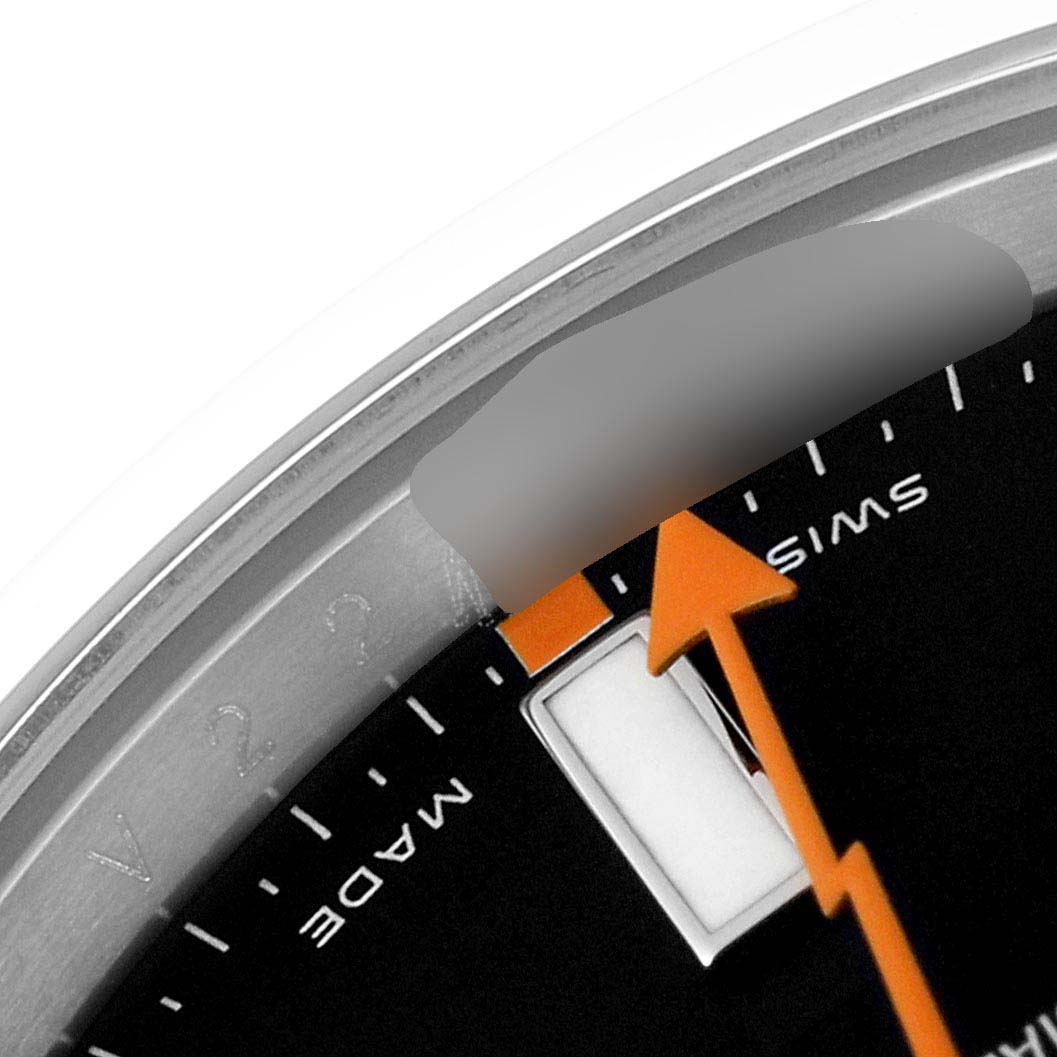 This close-up of the Rolex Milgauss 116400 Men's Stainless Steel Black Dial 116400 Men's Stainless Steel Black Dial watch shows the bezel, part of the dial with the Swiss marking, and an orange second hand.