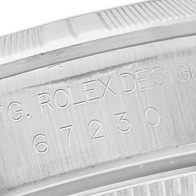 This image shows a close-up of the engraved serial number on the side of a Rolex Oyster Perpetual 67230 Women's Stainless Steel White Dial 67230 Women's Stainless Steel White Dial model watch.