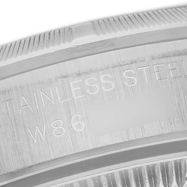 The image shows a close-up of the bezel and case edge of a Rolex Oyster Perpetual 67230 Women's Stainless Steel White Dial 67230 Women's Stainless Steel White Dial watch with visible engraving.