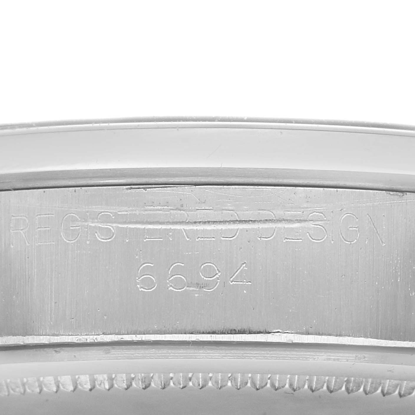 The image shows a close-up of the case side of the Rolex Vintage Collection model 6694, highlighting the engraved "REGISTERED DESIGN" and model number.
