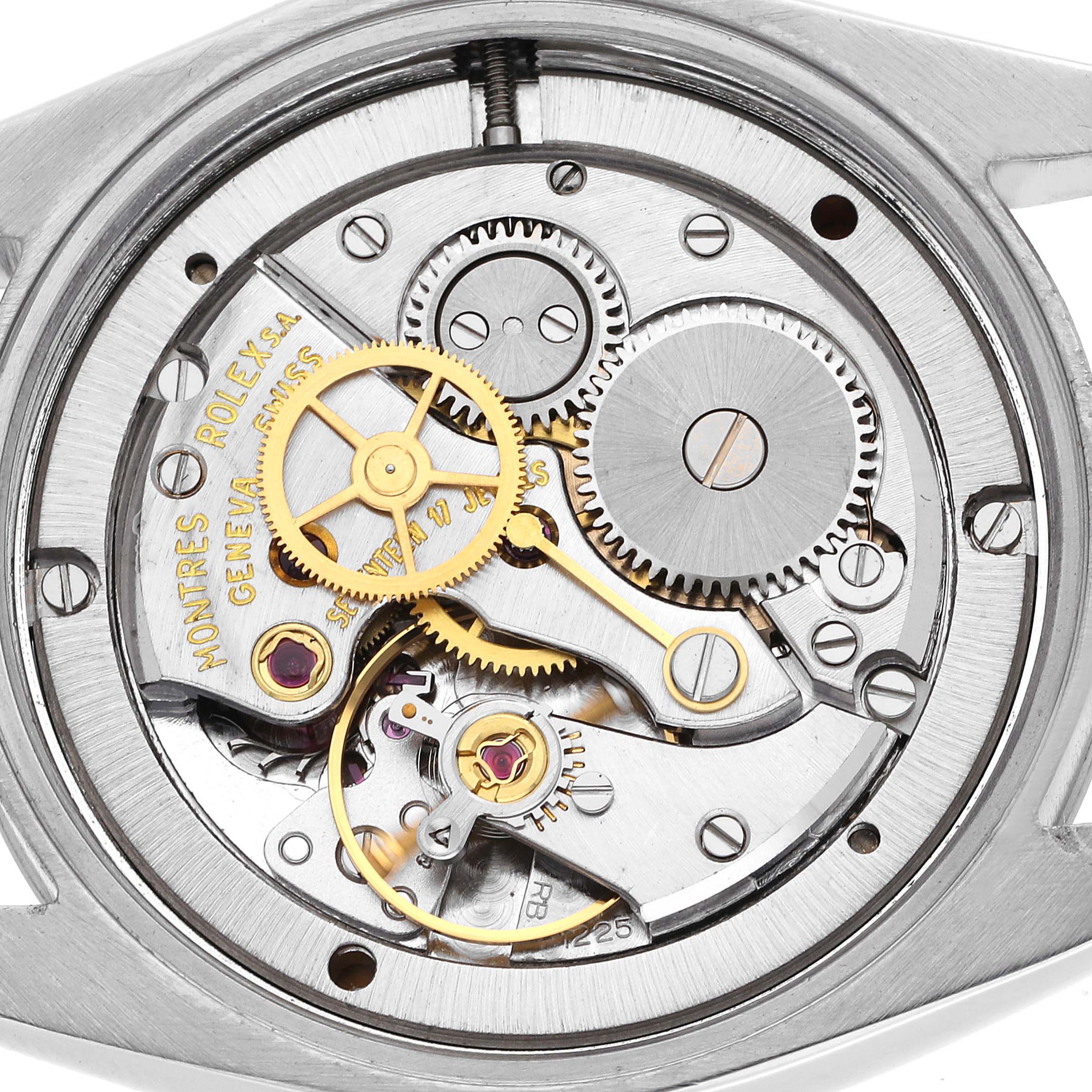 The image shows the inner mechanical workings of the Rolex Vintage Collection model 6694 men's watch, featuring gears and the movement mechanism.