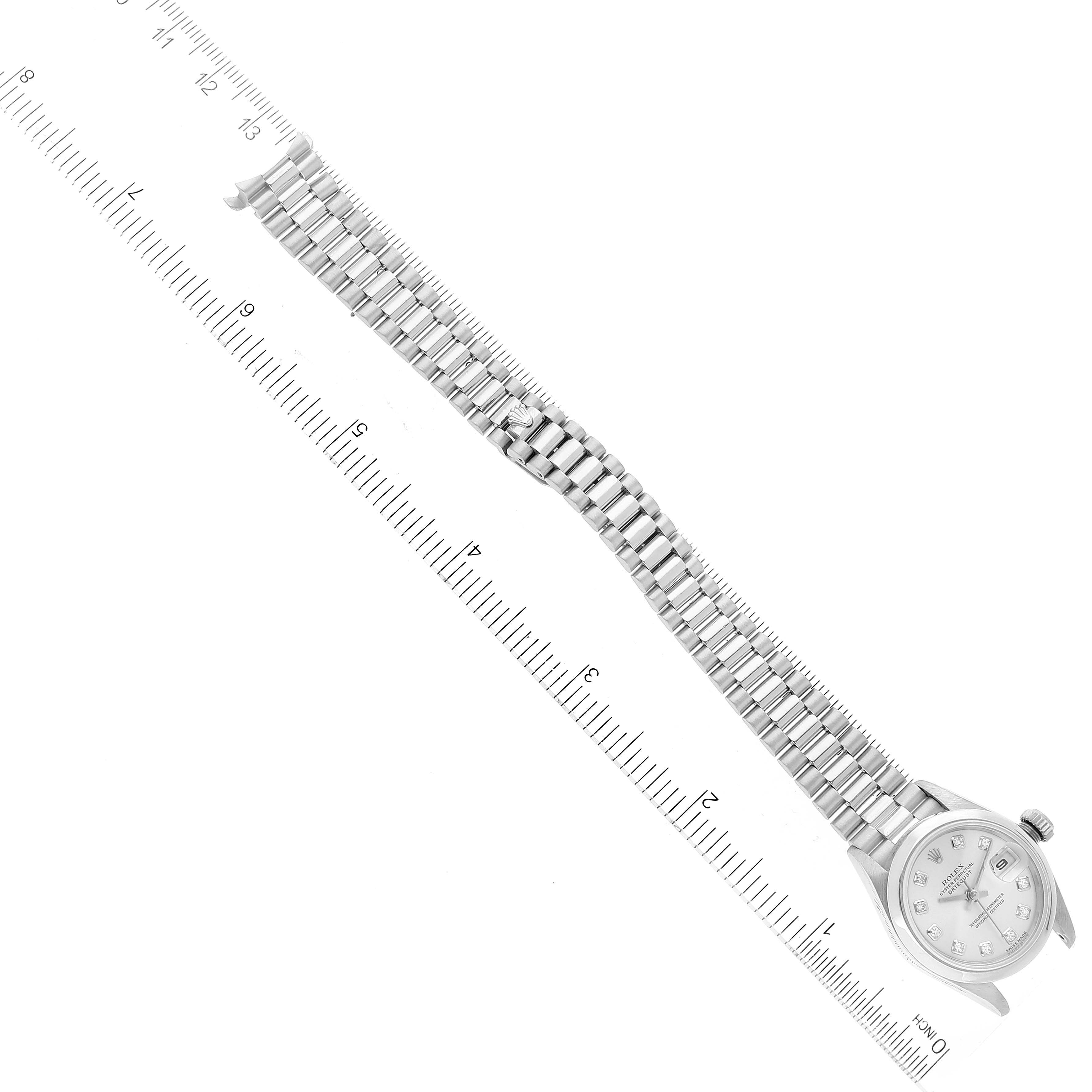 The image shows a Rolex President 79166 Women's Platinum Silver Dial 79166 Women's Platinum Silver Dial model watch laid flat next to a ruler to measure its length.