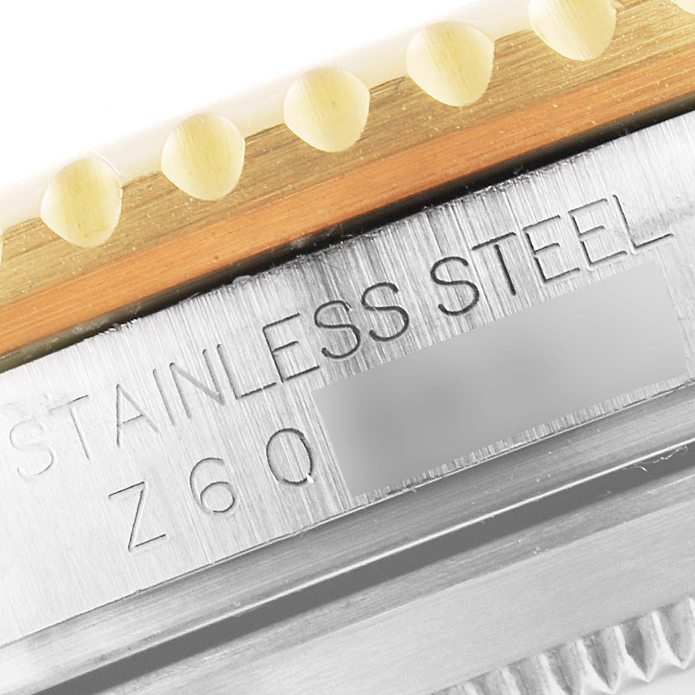 The image shows a close-up of the side of the Rolex Submariner 16613 Men's Steel and Gold (two tone) Blue Dial 16613 Men's Steel and Gold (two tone) Blue Dial watch, highlighting the engraved "STAINLESS STEEL" text and part of the bezel.