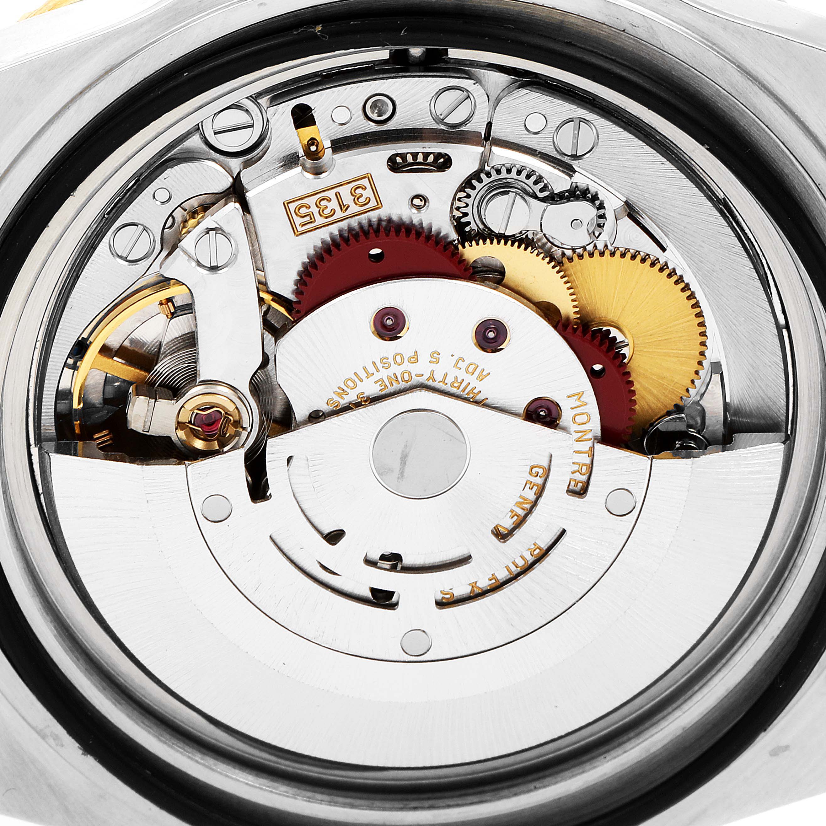 The image shows the internal mechanics of a Rolex Submariner 16613 Men
s Steel and Gold (two tone) Blue Dial 16613 Men
s Steel and Gold (two tone) Blue Dial watch from a rear view angle, highlighting the gears and movement components.