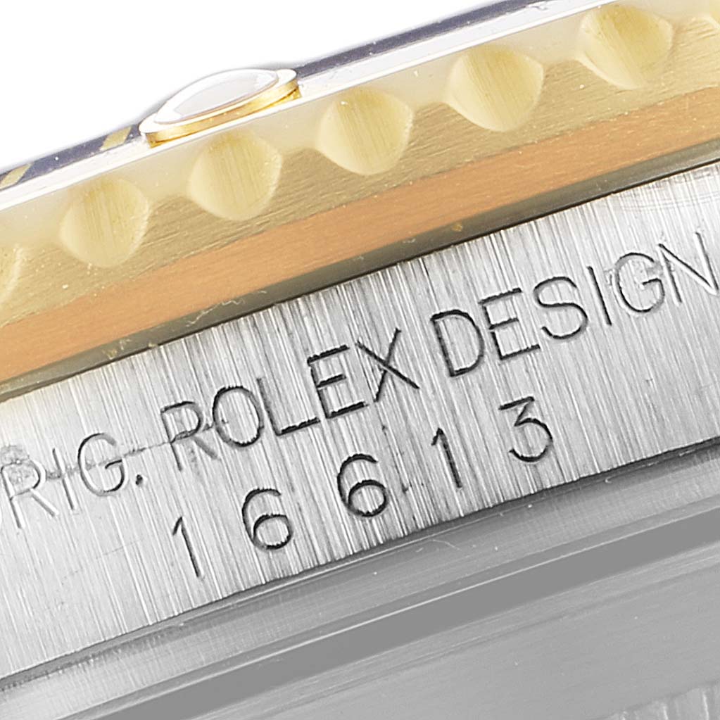 This close-up angle shows the engraved model number and part of the bezel of the Rolex Submariner 16613 Men
s Steel and Gold (two tone) Blue Dial 16613 Men
s Steel and Gold (two tone) Blue Dial.