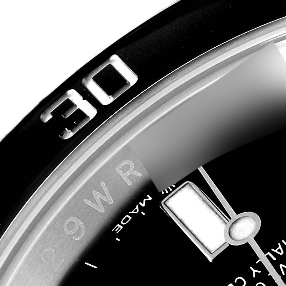 This close-up shows the bezel and dial details of a Rolex Submariner 124060 Men
s Stainless Steel Black Dial 124060 Men
s Stainless Steel Black Dial watch, highlighting the 30-minute marker and part of the hour hand.