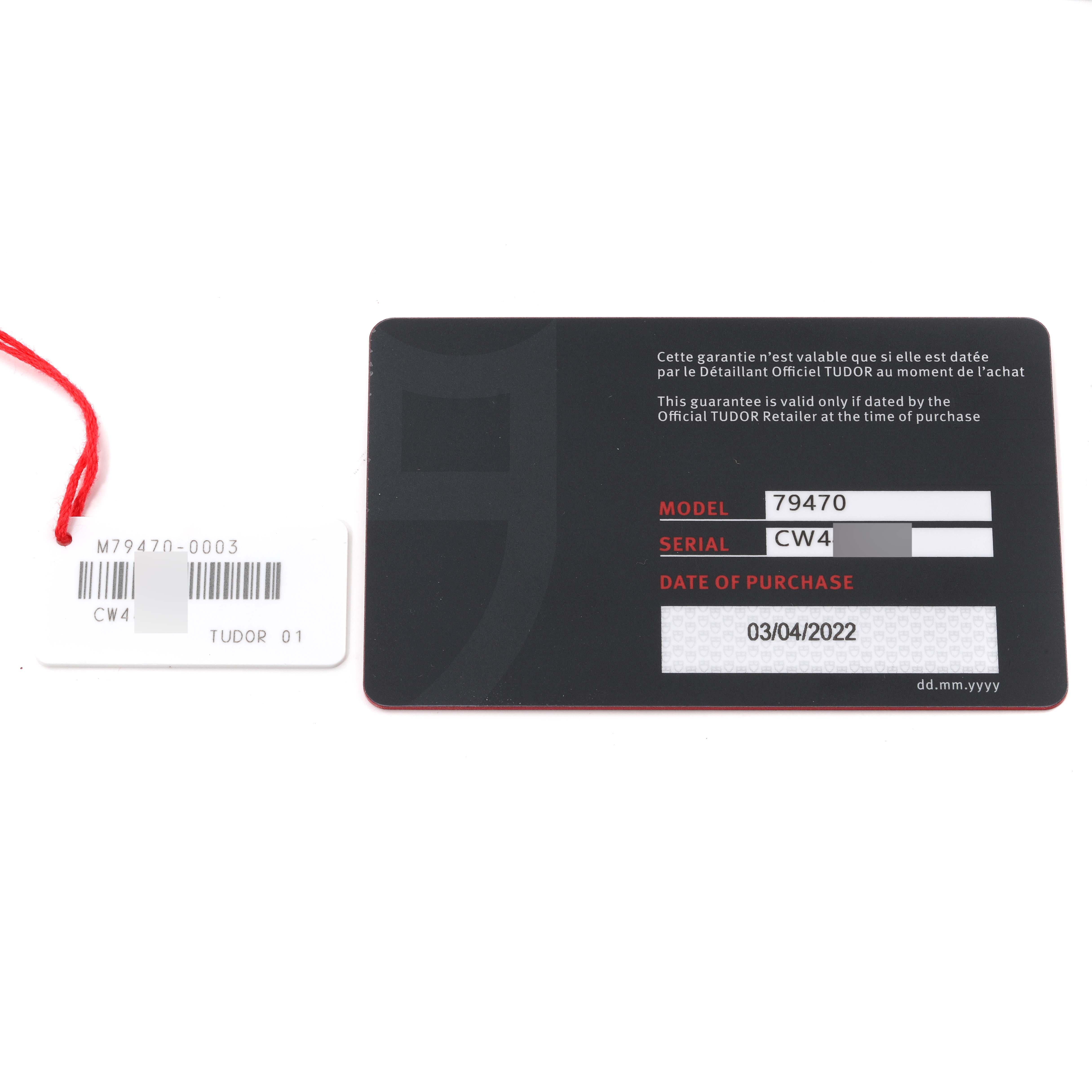 The image shows the warranty card and tag for the Tudor Heritage Black Bay M79470-0003 Men
s Stainless Steel Black Dial M79470-0003 Men
s Stainless Steel Black Dial model 79470 watch.