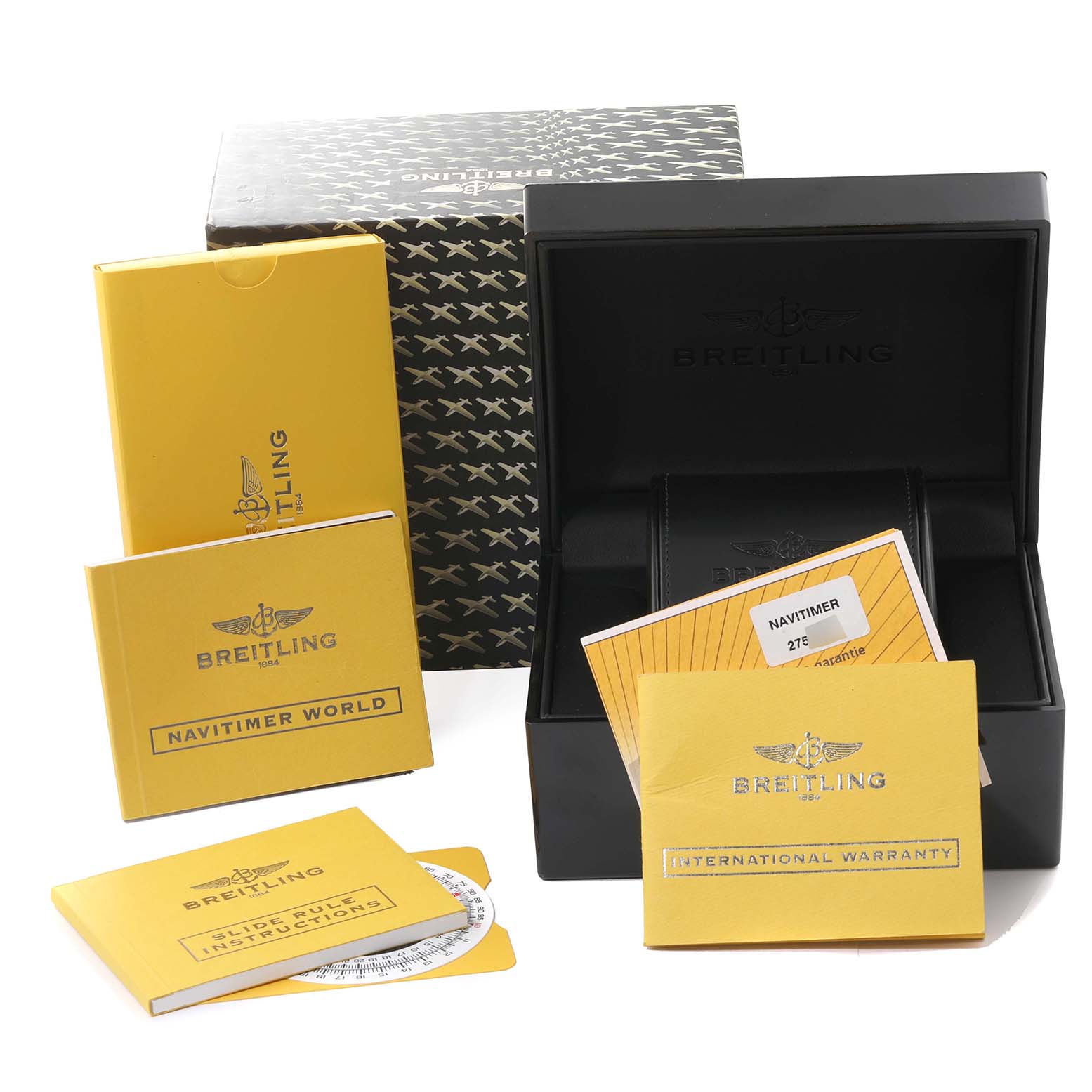 The image shows the packaging, manuals, and warranty card for a Breitling Navitimer A24322 Men
s Stainless Steel Black Dial A24322 Men
s Stainless Steel Black Dial watch laid out at an angle.