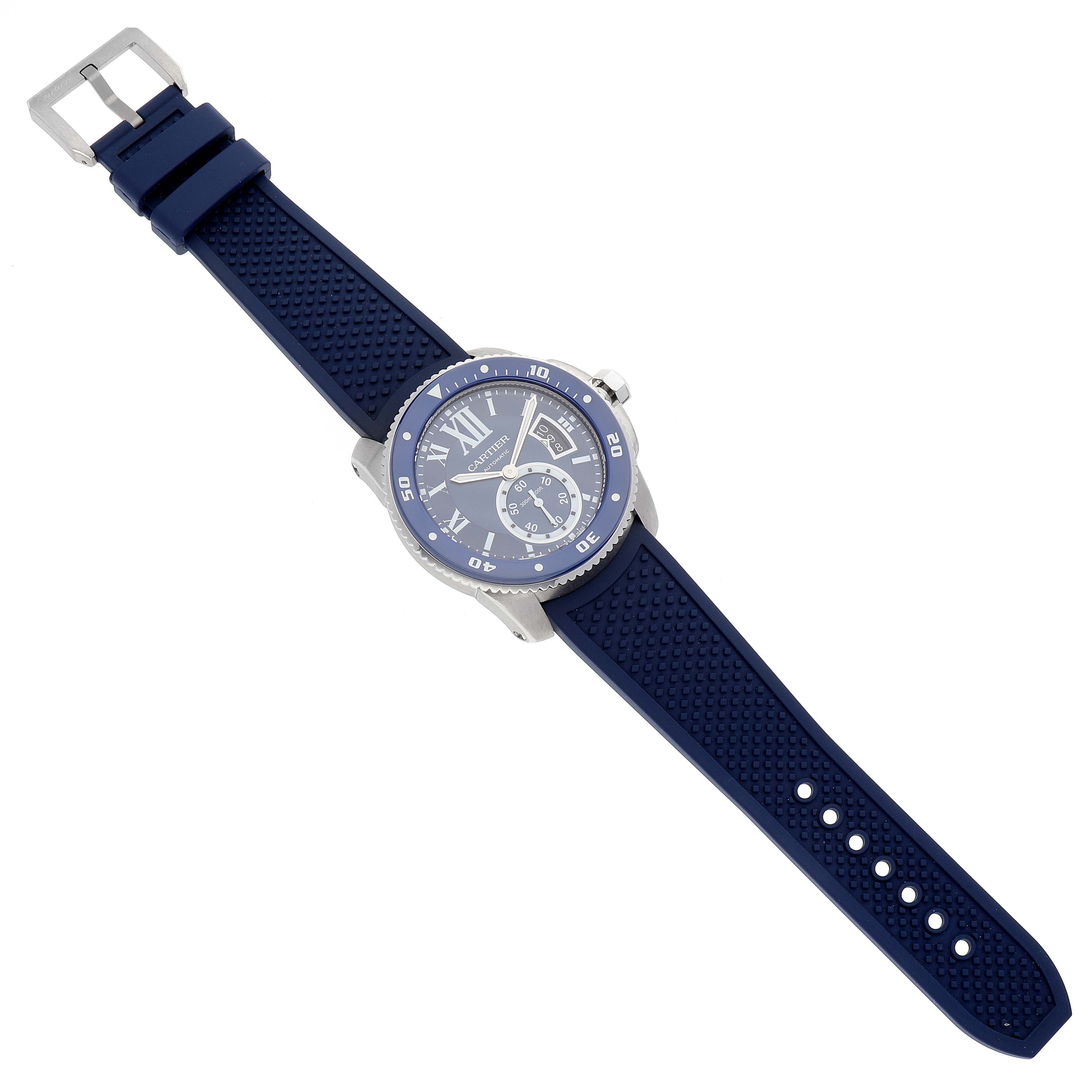The image shows a Calibre de Cartier watch by Cartier from a top-down angle, including its blue strap and watch face.
