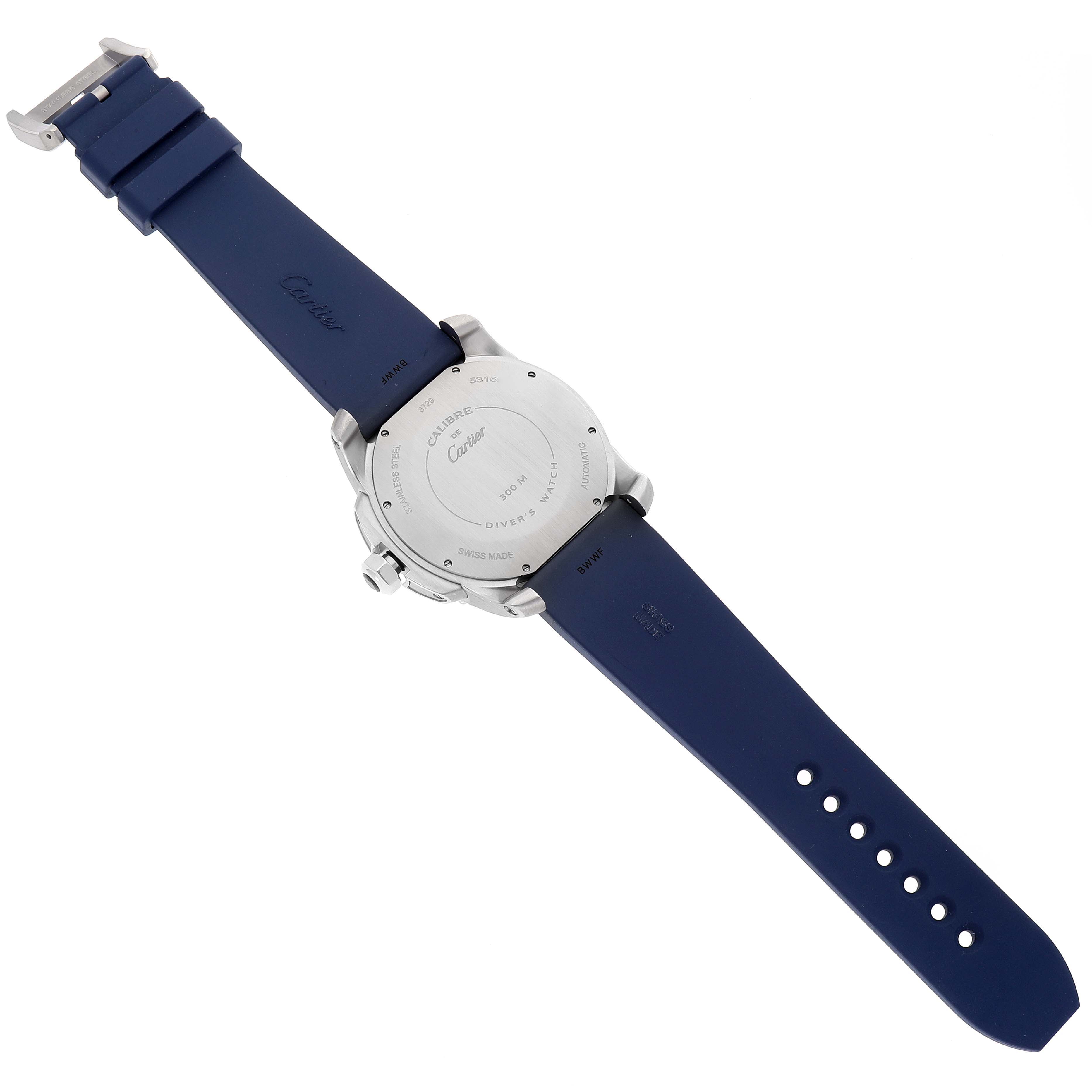 The image shows the back side of a Calibre de Cartier watch by Cartier, featuring its case back and blue strap.