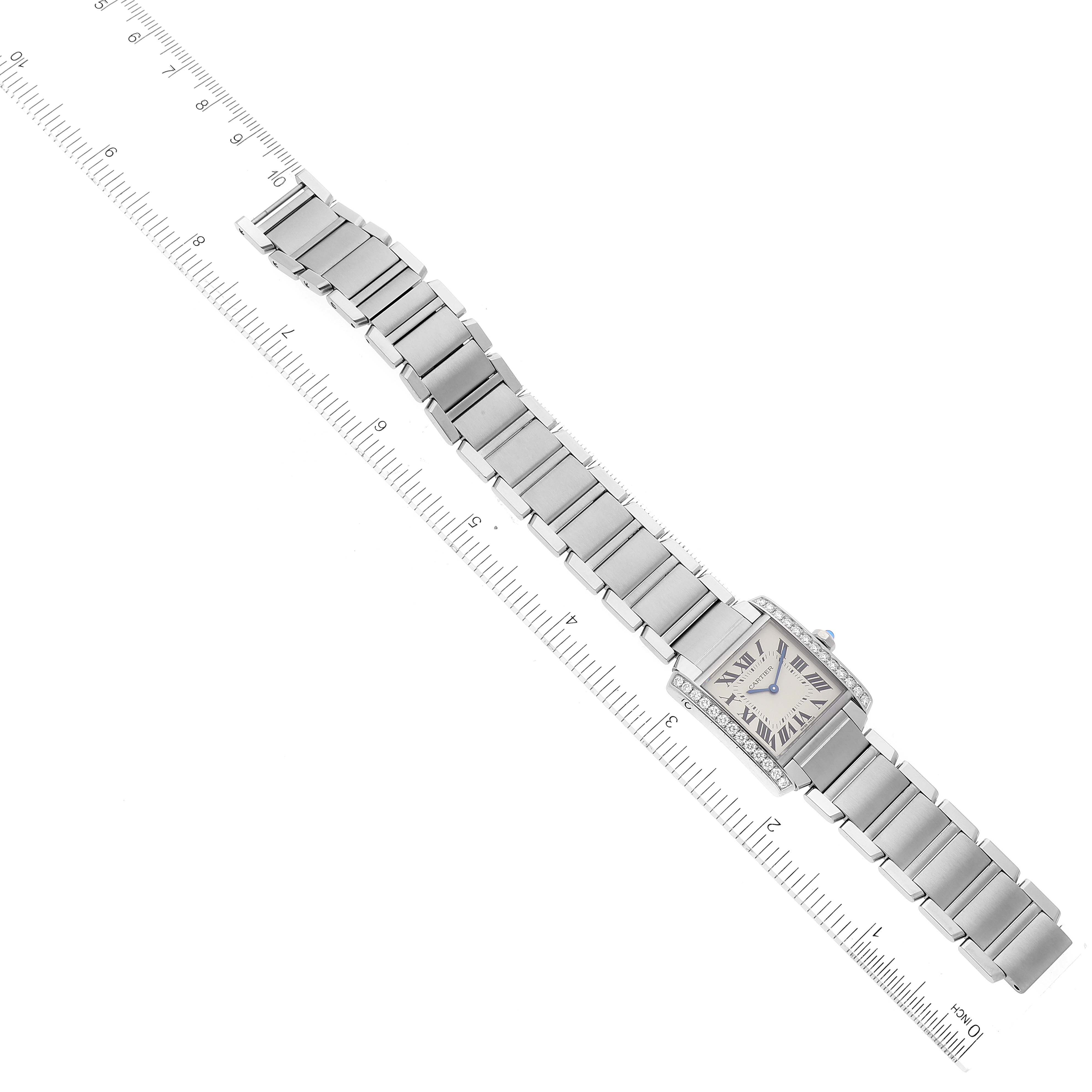The Cartier Tank Francaise W4TA0009 Women's Stainless Steel Silver Dial W4TA0009 Women's Stainless Steel Silver Dial watch is shown laid flat, displaying the entire bracelet and face, alongside a ruler for scale.