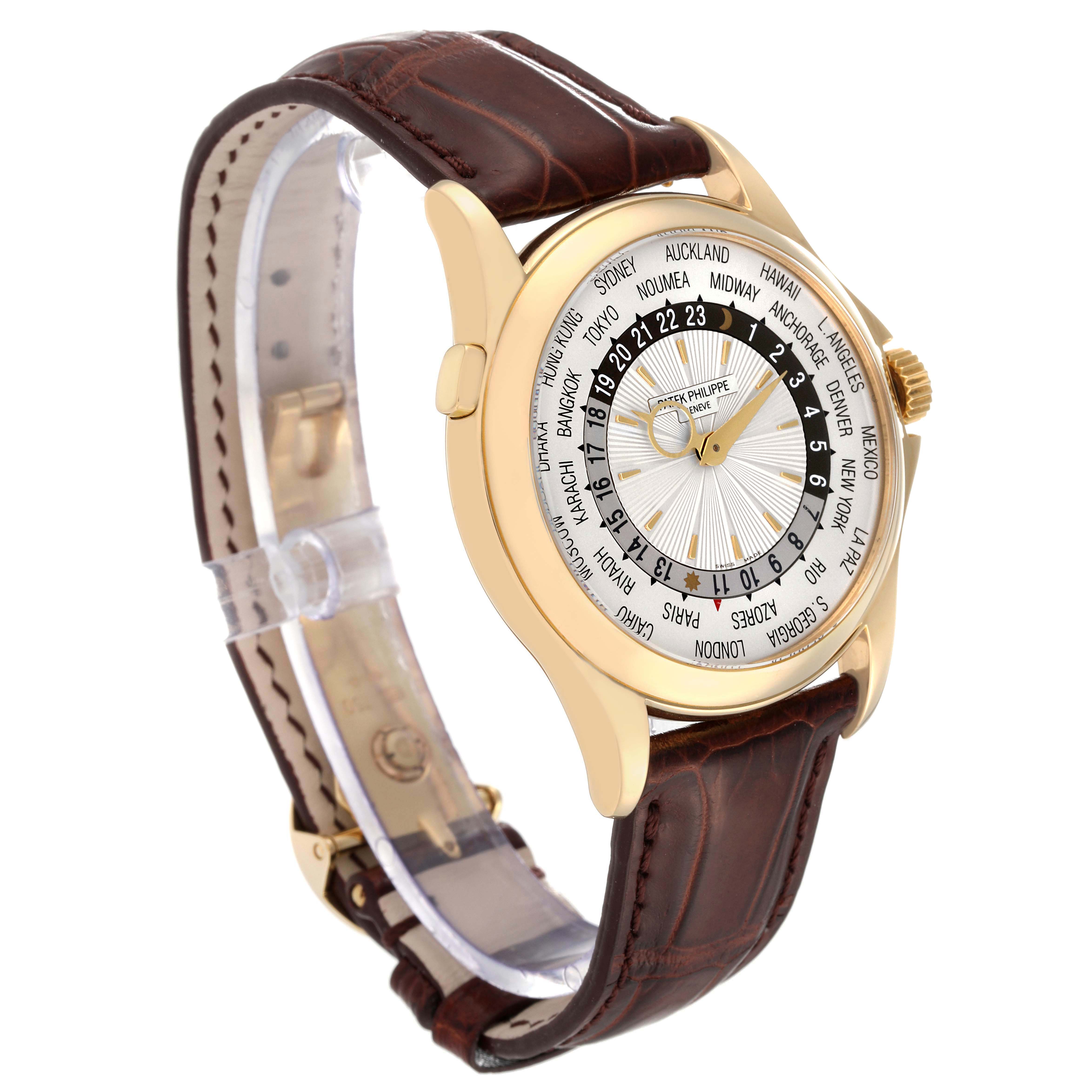 This Patek Philippe Complications 5130J Men
s Yellow Gold Silver Dial 5130J Men
s Yellow Gold Silver Dial model watch is shown at a three-quarter angle, highlighting its brown leather strap and world time dial.