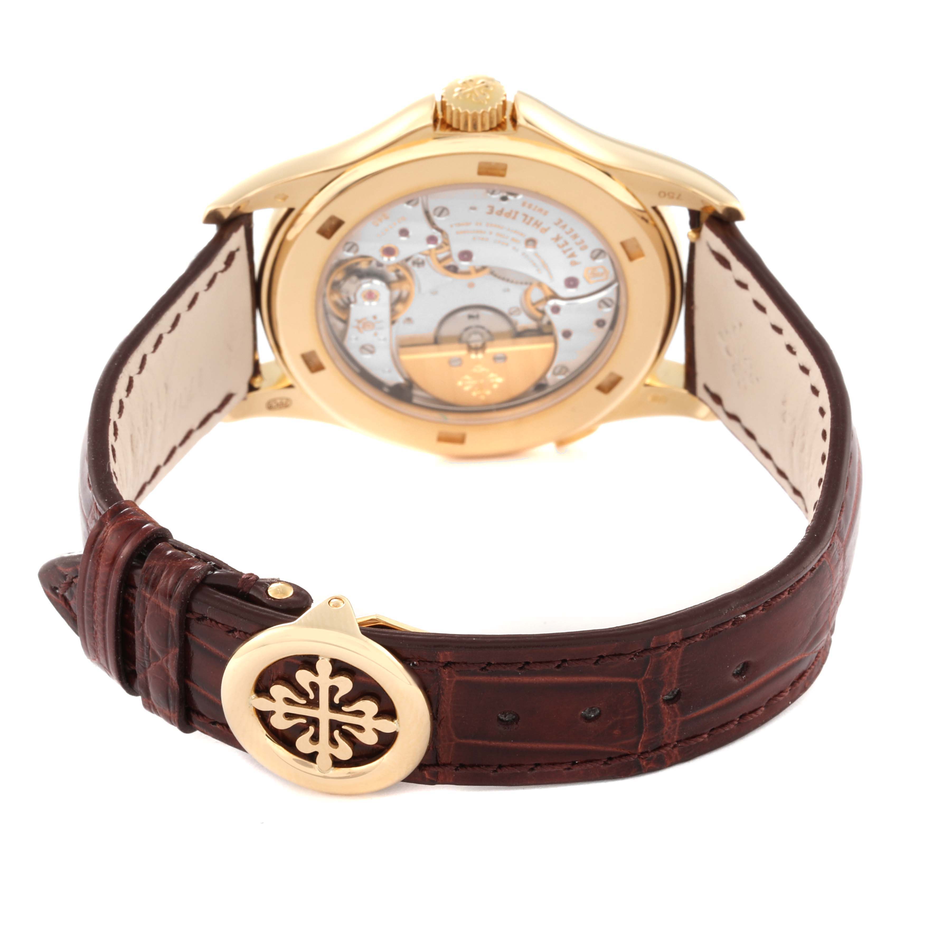 The image shows the back view of the Patek Philippe Complications 5130J Men
s Yellow Gold Silver Dial 5130J Men
s Yellow Gold Silver Dial watch, highlighting its movement and brown leather strap.