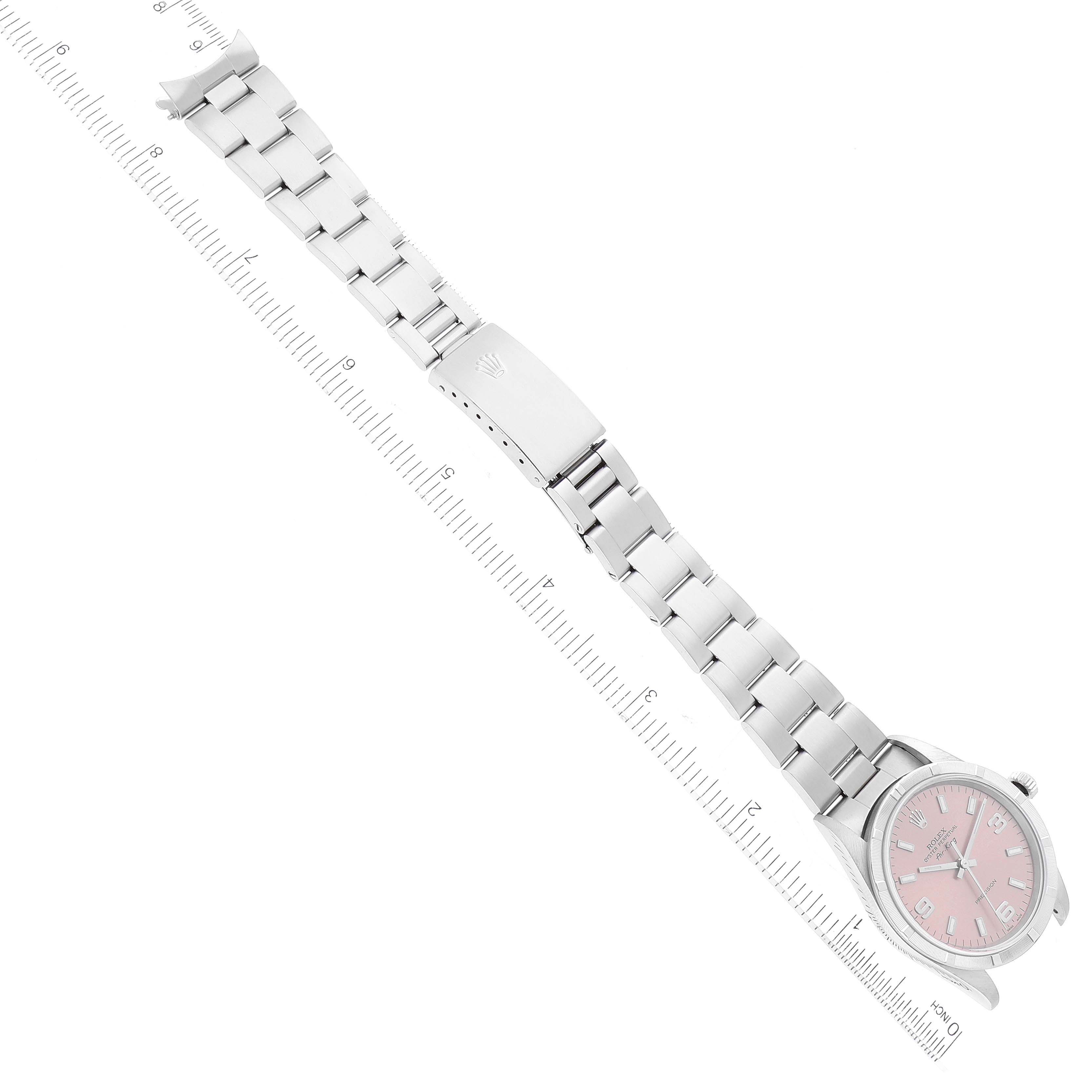 The image displays a Rolex Air-King 14010 Men's Stainless Steel Pink Dial 14010 Men's Stainless Steel Pink Dial watch from an overhead angle, highlighting the watch's face, bracelet, and clasp, with a ruler underneath for scale.