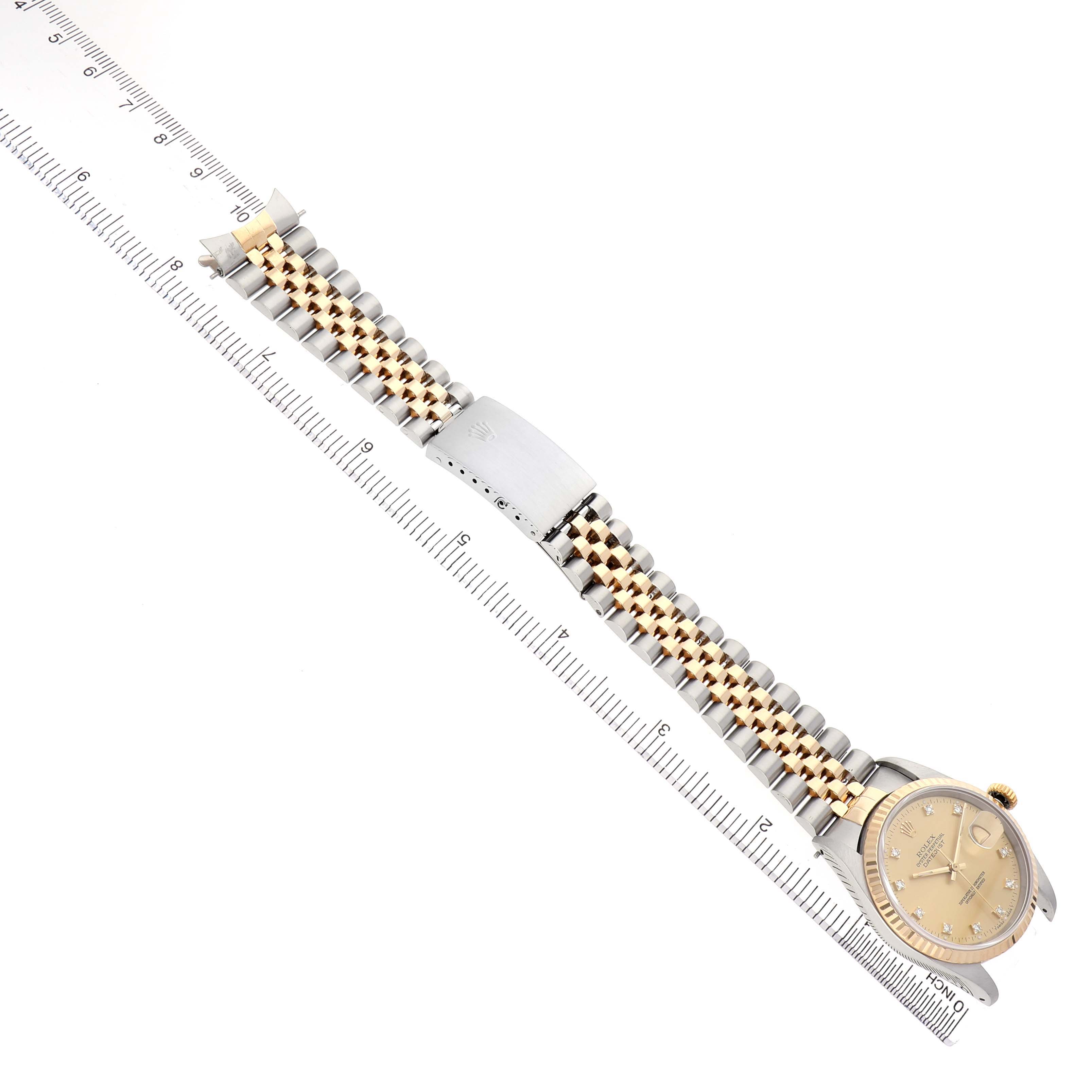 The Rolex Datejust 16233 Men's Steel and Gold (two tone) Champagne Dial watch is shown from an angled top view, displaying the face, bezel, and full two-tone bracelet with a ruler for scale.