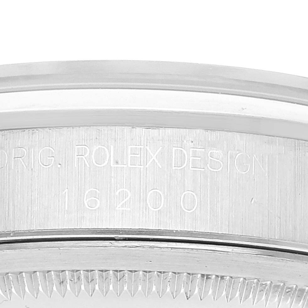 The image shows a close-up of the side case with engraved text on a Rolex Datejust 16200 Men's Stainless Steel Black Dial 16200 Men's Stainless Steel Black Dial model, focusing on the serial number and bezel area.
