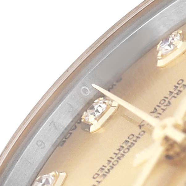 The image shows a close-up of the dial on a Mid-Size Rolex watch, featuring a gold tone, diamond indices, and part of the hands.
