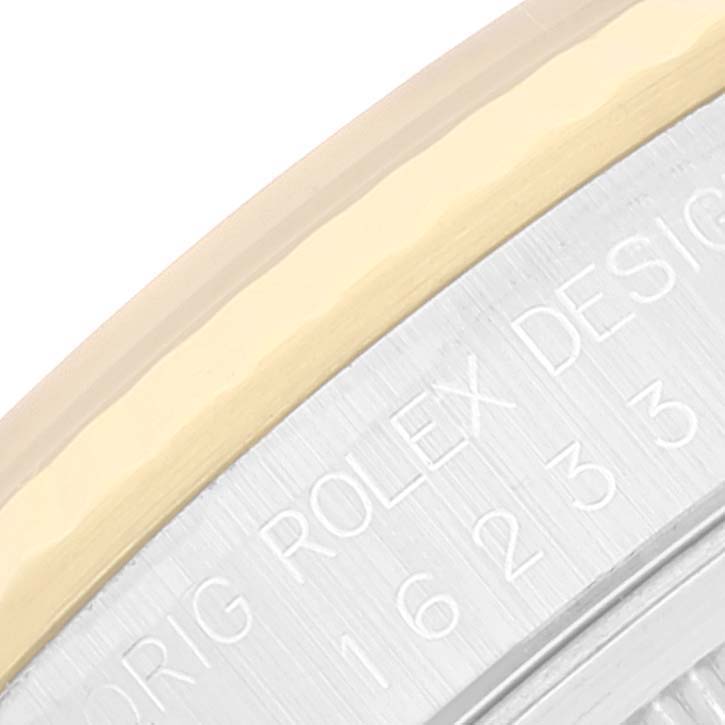 The image shows a close-up of the bezel and engraved back case of a Rolex Datejust 16233 Men's Steel and Gold (two tone) Black Dial 16233 Men's Steel and Gold (two tone) Black Dial watch.