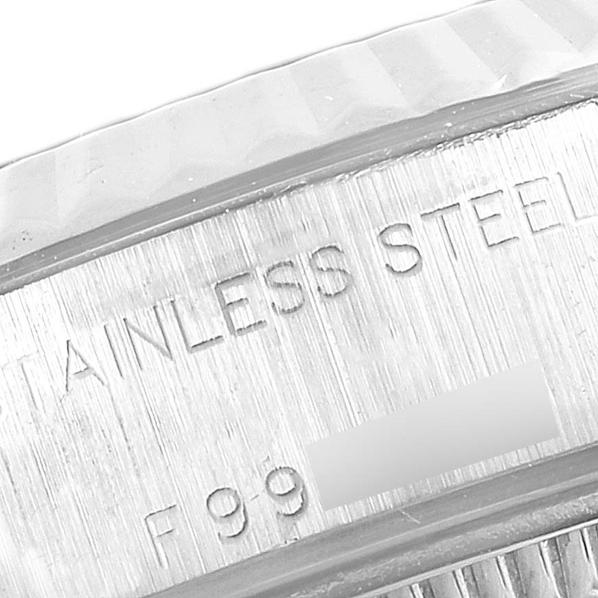 This is a close-up of the side engraving on a Rolex Datejust 79174 Women
s Stainless Steel Silver Dial 79174 Women
s Stainless Steel Silver Dial, showing "Stainless Steel" and part of a serial number.
