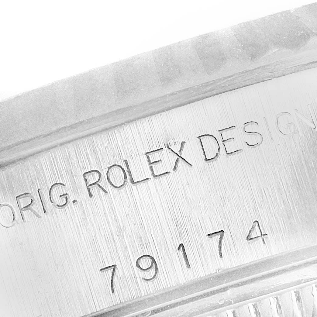 This close-up image shows the engraved serial number and "ROLEX DESIGN" text on the case of a Rolex Datejust 79174 Women
s Stainless Steel Silver Dial 79174 Women
s Stainless Steel Silver Dial watch.