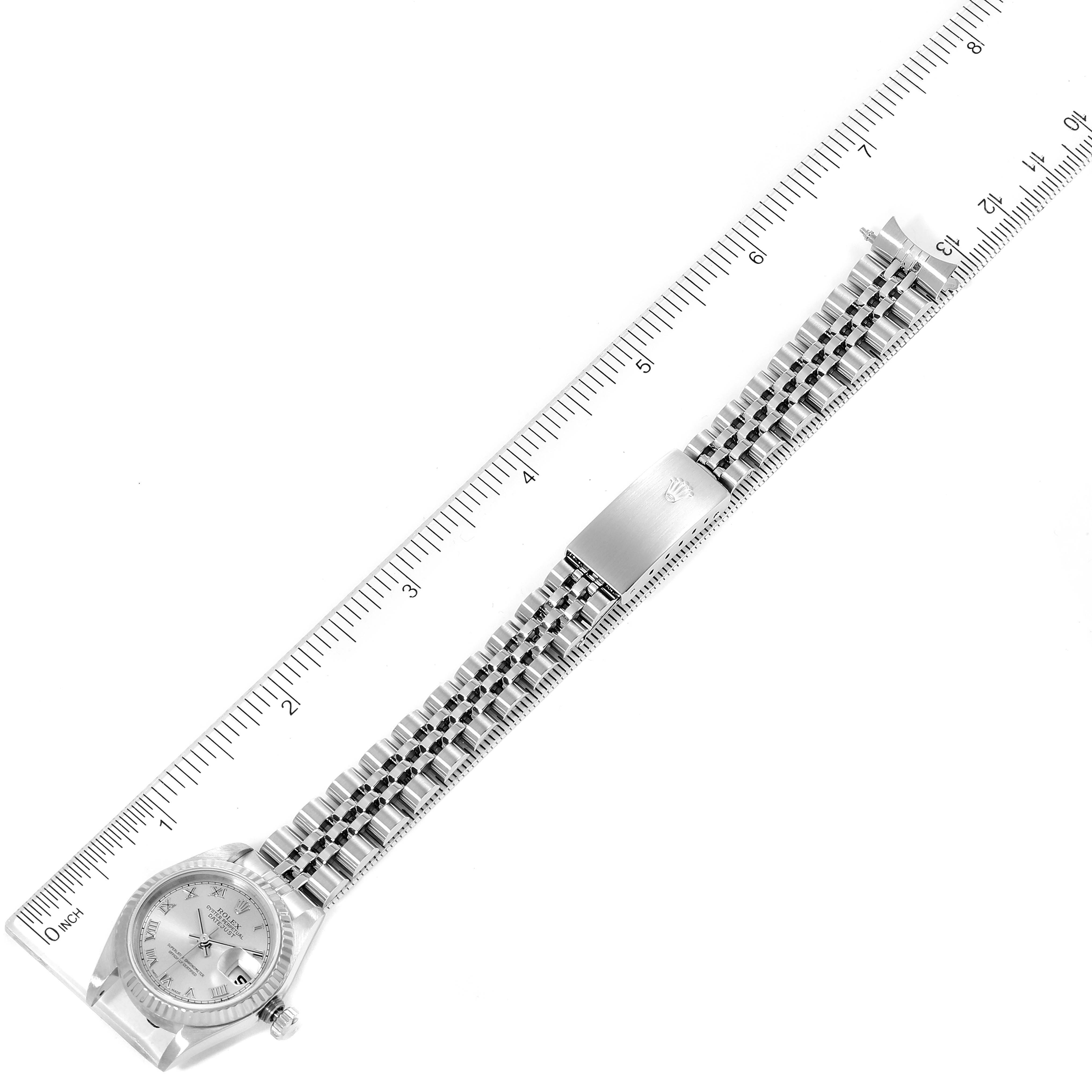 The image shows an overhead view of a Rolex Datejust 79174 Women's Stainless Steel Silver Dial 79174 Women's Stainless Steel Silver Dial watch with a ruler measuring its length.