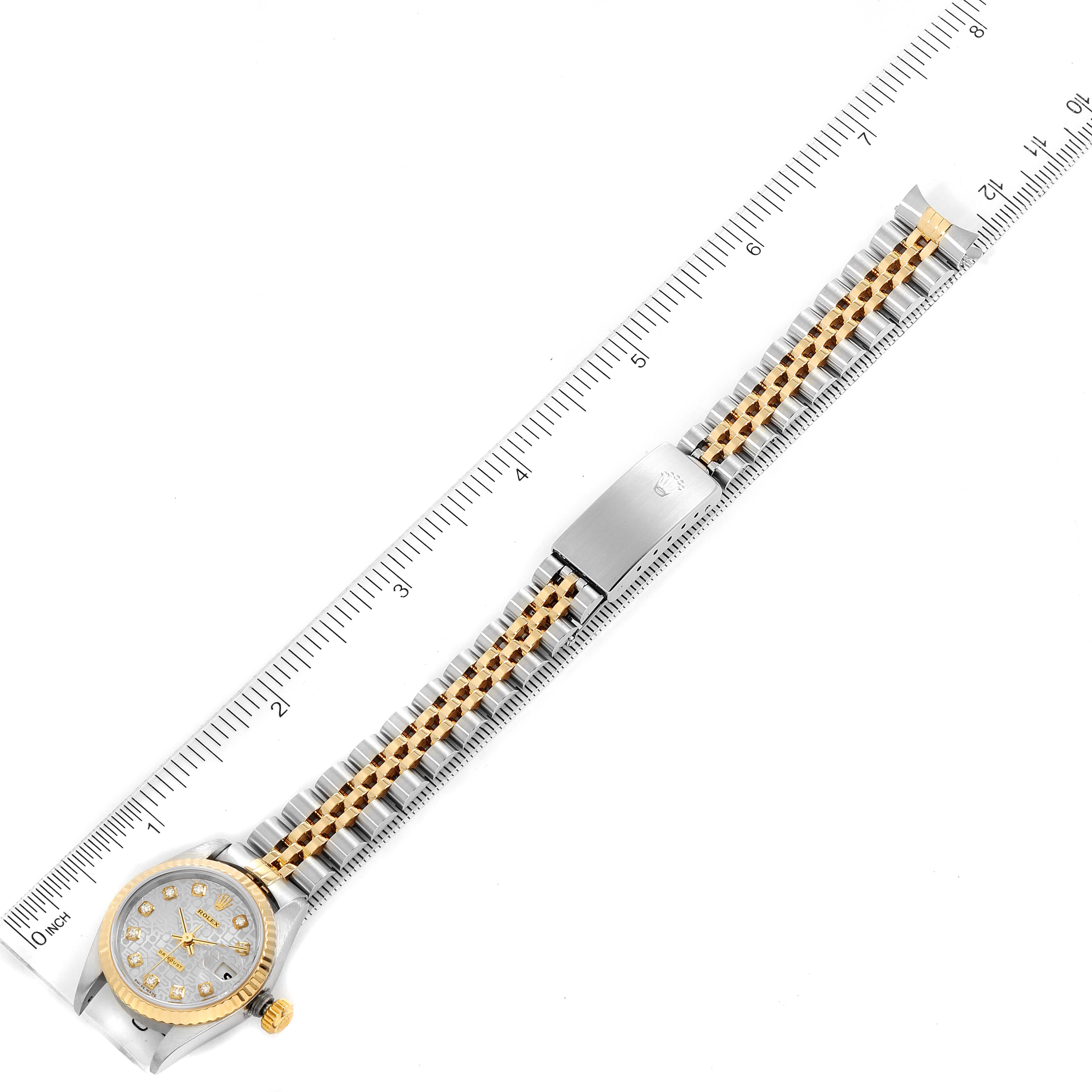 This image shows a top view of a Rolex Datejust 79173 Women
s Steel and Gold (two tone) Silver Dial 79173 Women
s Steel and Gold (two tone) Silver Dial watch with a two-tone bracelet and clasp, measured with a ruler.