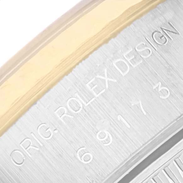 This image shows a close-up of the side of a Rolex Datejust 69173 Women
s Steel and Gold (two tone) Champagne Dial 69173 Women
s Steel and Gold (two tone) Champagne Dial watch case featuring the inscription "ORIG. ROLEX DESIGN 69173."