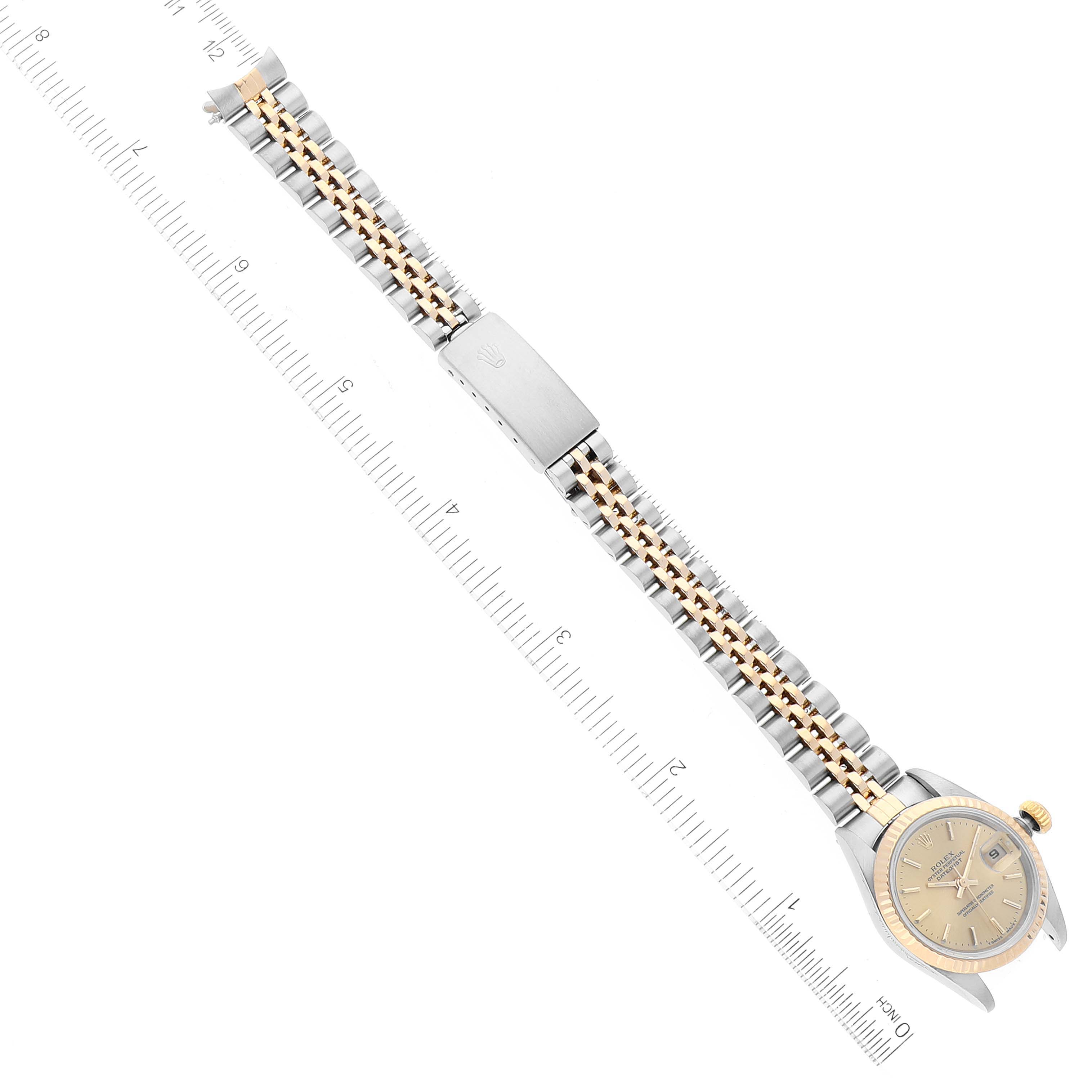 The image shows an overhead view of a Rolex Datejust 69173 Women
s Steel and Gold (two tone) Champagne Dial 69173 Women
s Steel and Gold (two tone) Champagne Dial watch, highlighting the full band and face alongside a measuring ruler.