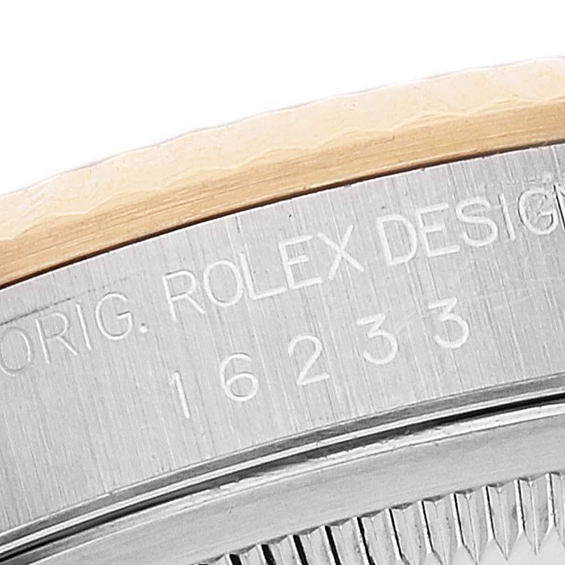 The image shows a close-up of the Rolex Datejust 16233 Men's Steel and Gold (two tone) Beige Dial 16233 Men's Steel and Gold (two tone) Beige Dial model's side case with engravings and part of the bezel.