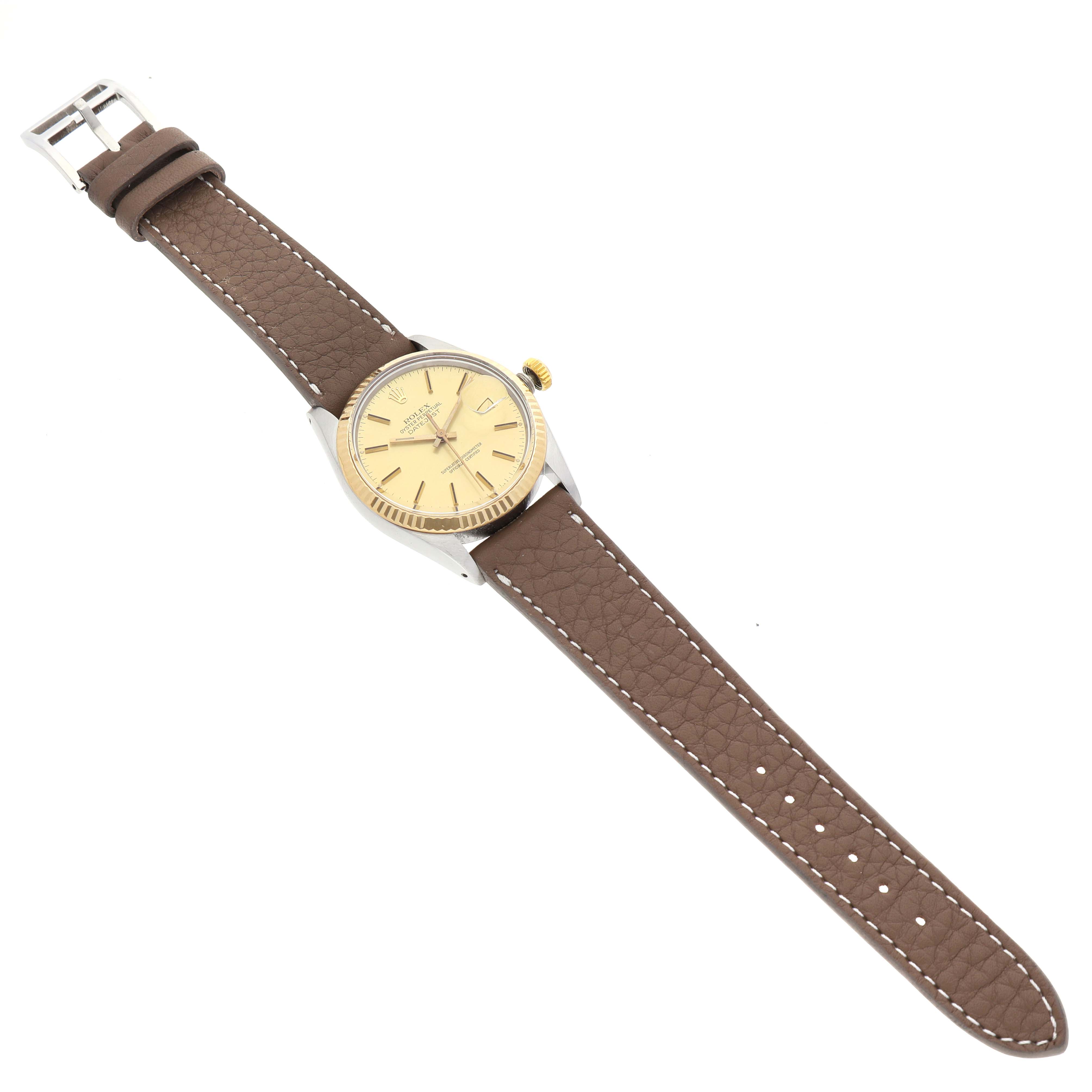 The Rolex Datejust 16013 Men's Steel and Gold (two tone) Champagne Dial watch is shown from a top-down angle, featuring the dial, bezel, crown, and brown leather strap.