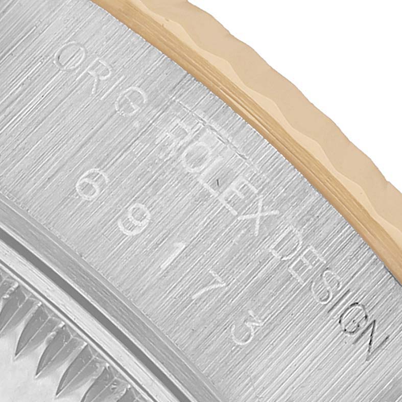 The image shows an angled close-up of the bezel and engravings on a Rolex Datejust 69173 Women's Steel and Gold (two tone) White Dial watch.