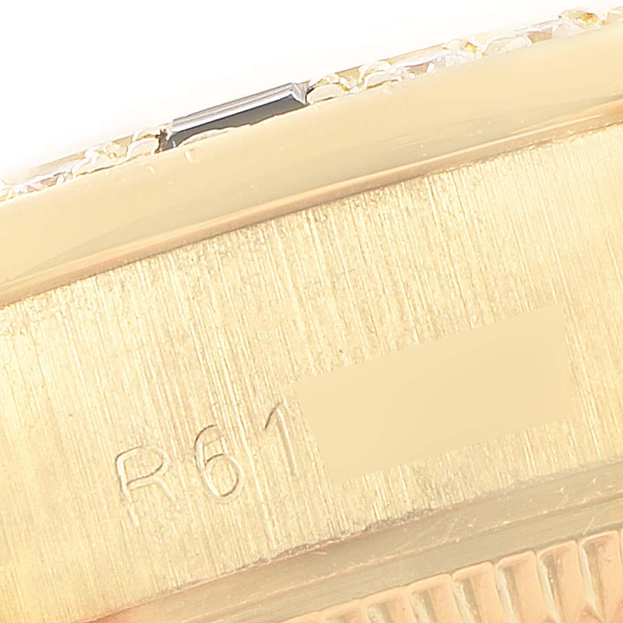 This image shows a close-up of the side of a Rolex President 69088 Women's Yellow Gold Blue Dial 69088 Women's Yellow Gold Blue Dial model watch, featuring part of the bezel and casing with engravings.
