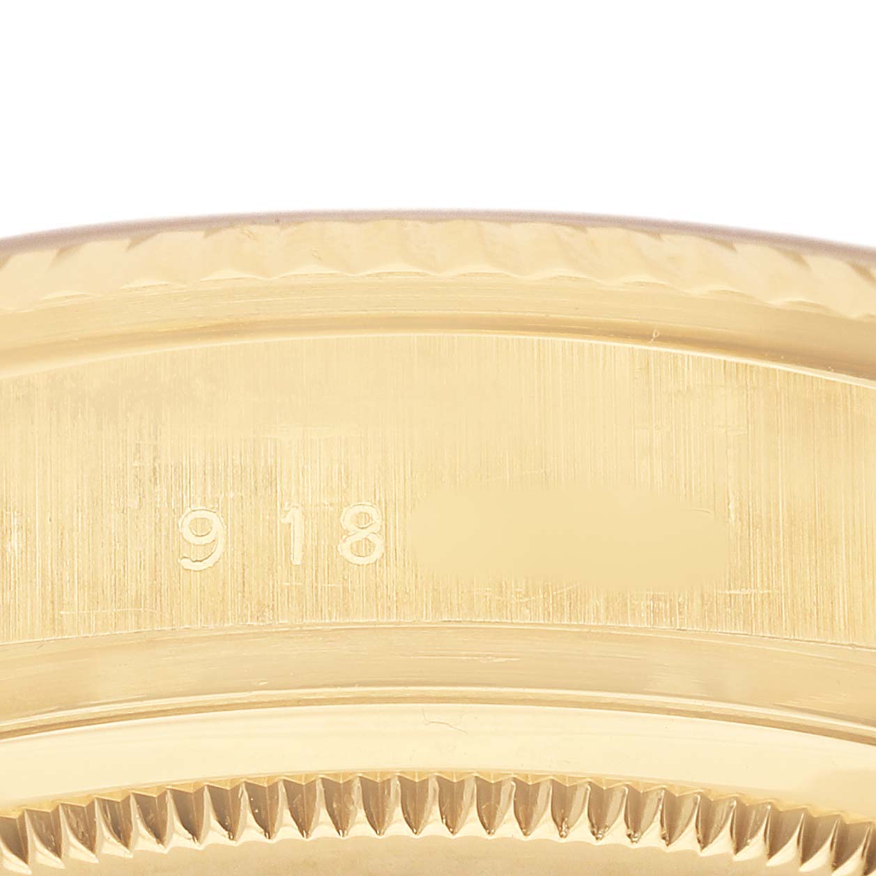 The image shows a close-up of the side of the bezel and case of a Rolex President 18038 Men's Yellow Gold Champagne Dial watch, displaying part of its engraving.