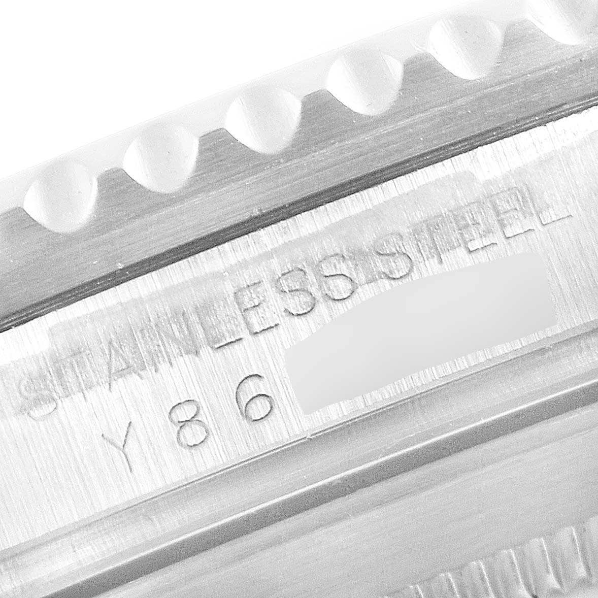 The image shows a close-up of the stainless steel engraving on the Rolex Submariner 16610 Men
s Stainless Steel Black Dial 16610 Men
s Stainless Steel Black Dial
s side, including part of the toothed bezel.