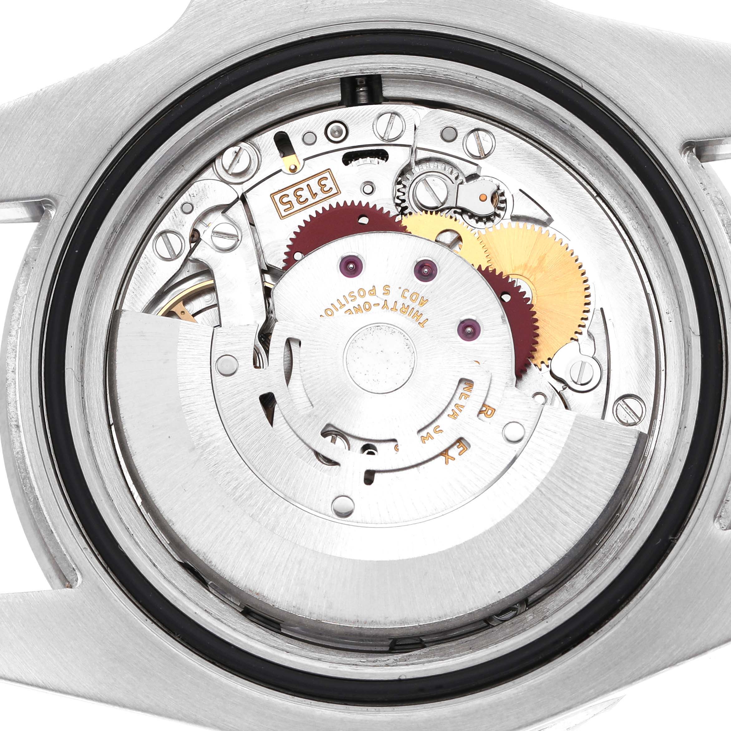The image shows the interior mechanism of a Rolex Submariner M116610LN-0001 Men's Stainless Steel Black Dial watch from a rear view, highlighting gears and movement parts.