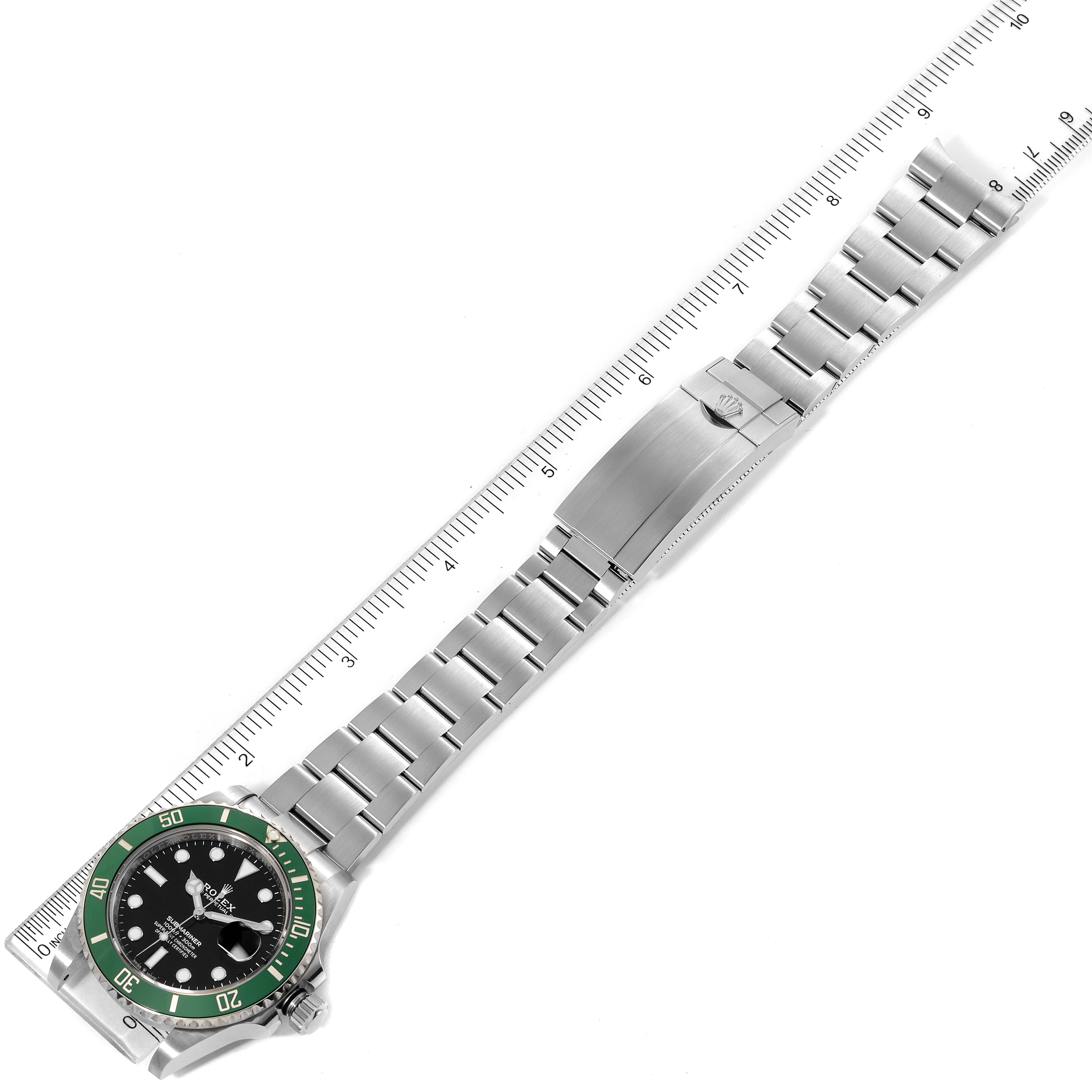 The image shows a top-down view of a Rolex Submariner 126610LV Men's Stainless Steel Black Dial 126610LV Men's Stainless Steel Black Dial watch, focusing on the complete band and face, with a measuring scale beside it.