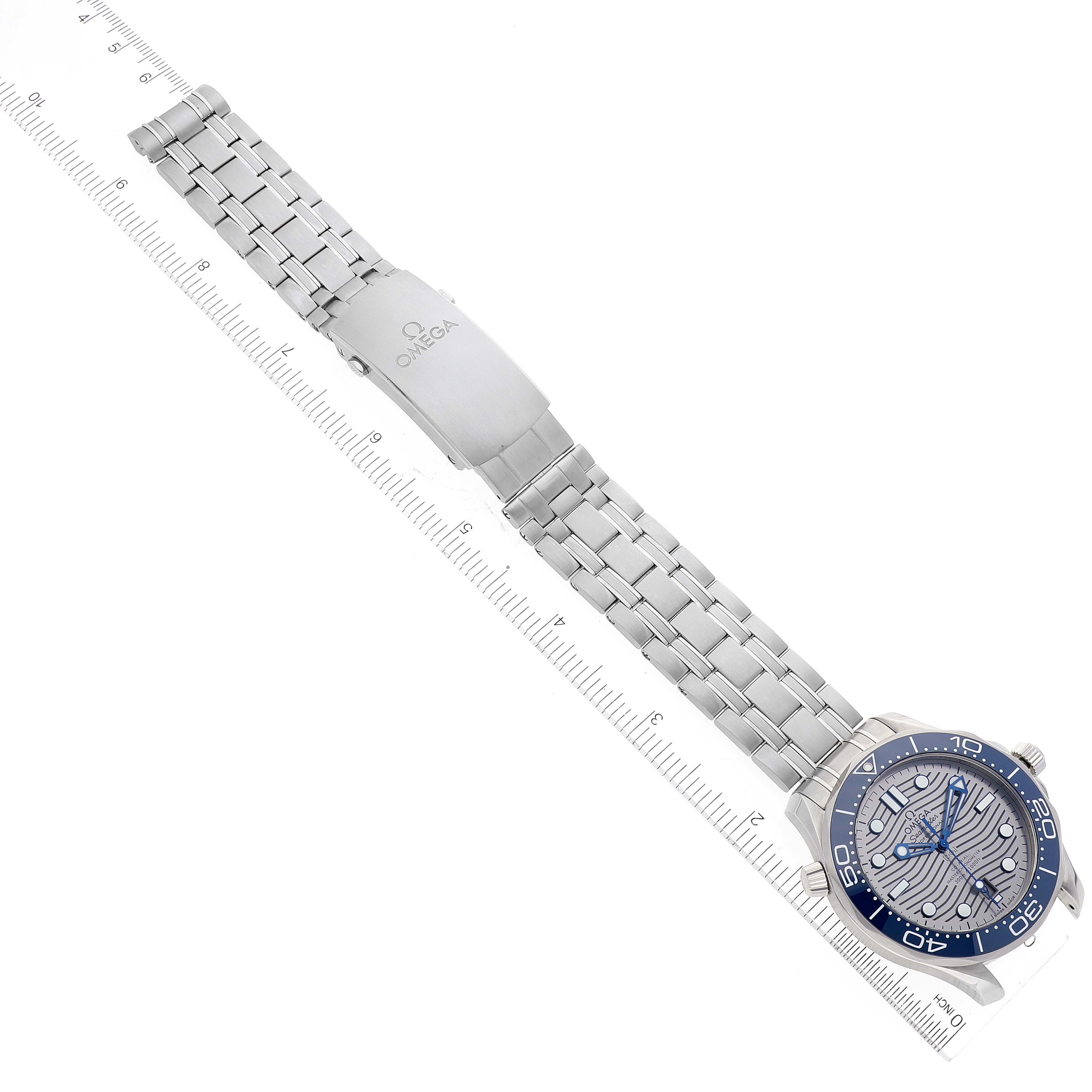 The Omega Seamaster 210.30.42.20.06.001 Men's Stainless Steel Grey Dial 210.30.42.20.06.001 Men's Stainless Steel Grey Dial watch is shown from the top angle, highlighting the bracelet, clasp, and face alongside a ruler for scale.
