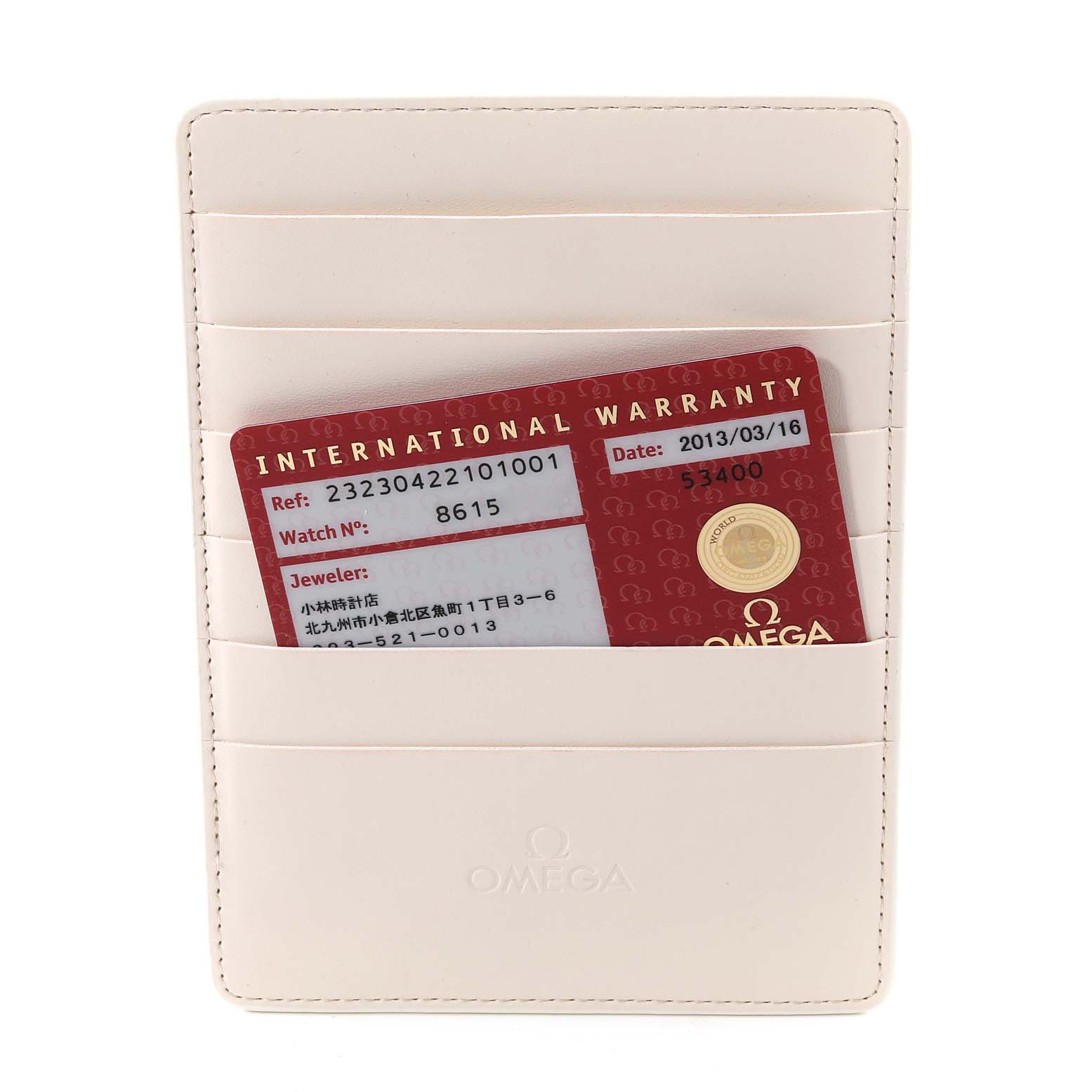 The image shows an Omega Planet Ocean 232.30.42.21.01.003 Men
s Stainless Steel Black Dial 232.30.42.21.01.003 Men
s Stainless Steel Black Dial model
s international warranty card in a beige cardholder, viewed from the front.