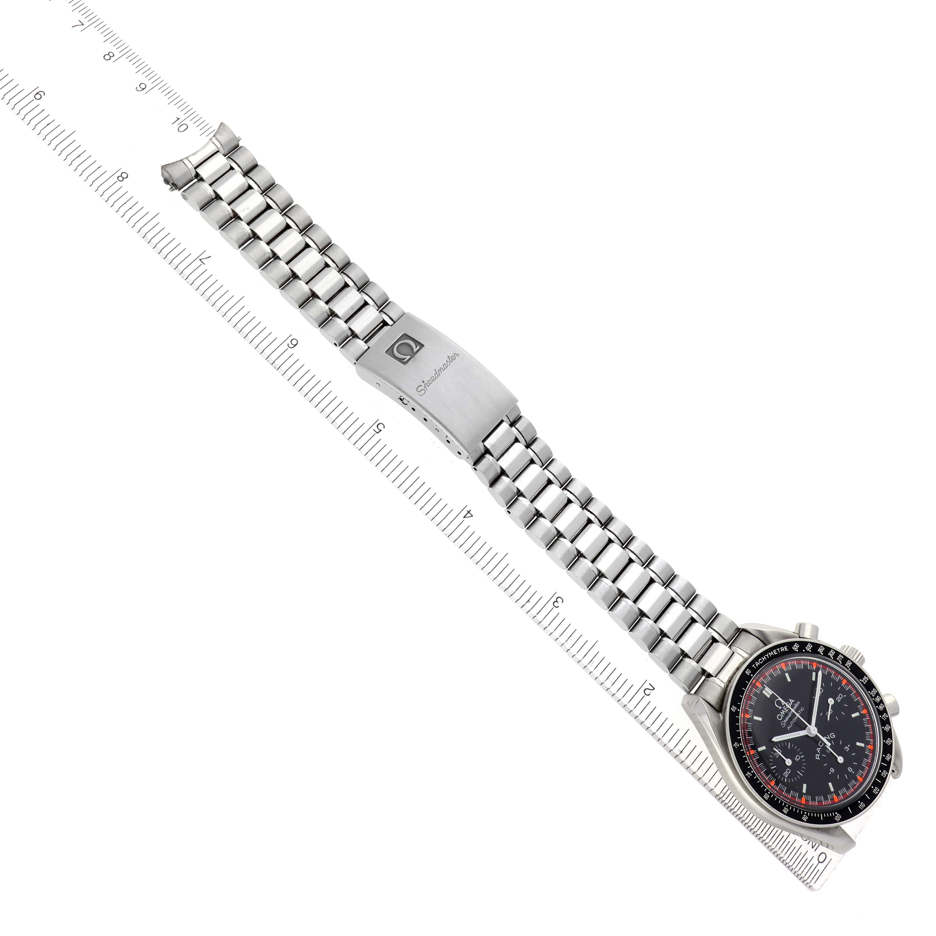 The Omega Speedmaster model 3518.50.00 is shown from a top view, displaying its full bracelet, clasp, and face positioned diagonally alongside a ruler.