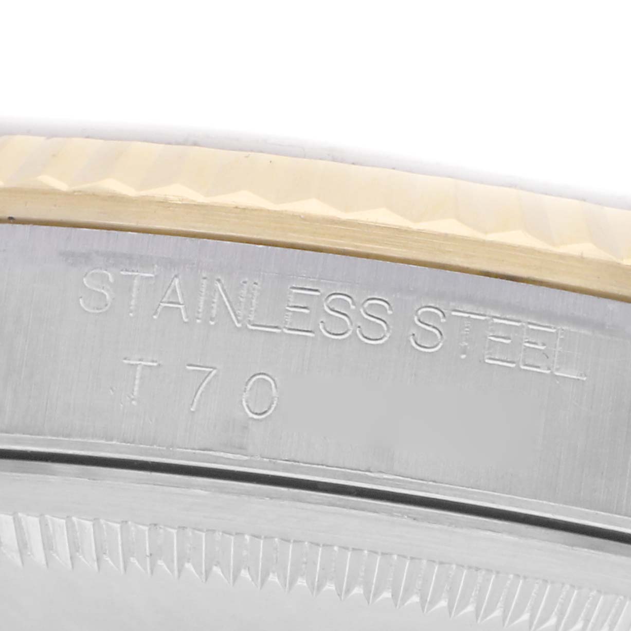 The image shows a close-up of the side of a Rolex Datejust model 16233, focusing on the stainless steel bezel with engraved text.