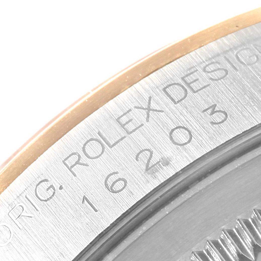 The image shows an angled close-up of the engraved bezel on a Rolex Datejust 16203 Men
s Steel and Gold (two tone) Grey Dial 16203 Men
s Steel and Gold (two tone) Grey Dial watch.