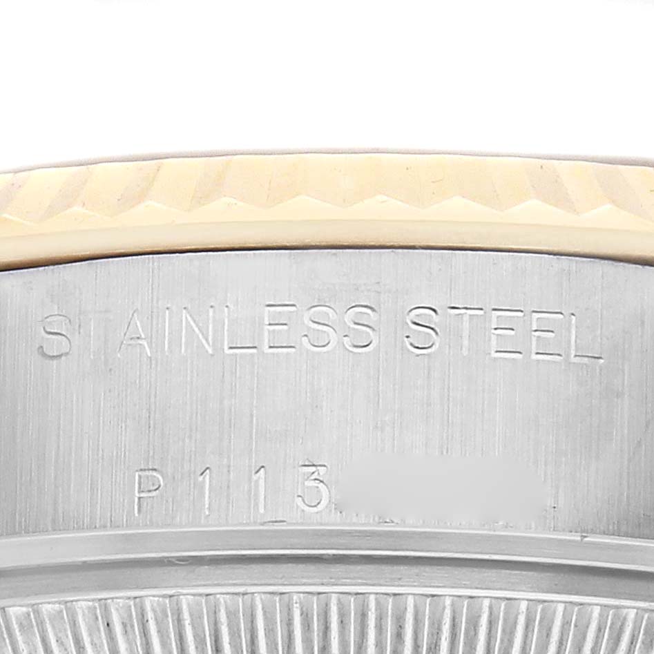 The image shows a close-up of the stainless steel back case of the Rolex Datejust model 79173, with part of the fluted bezel visible.