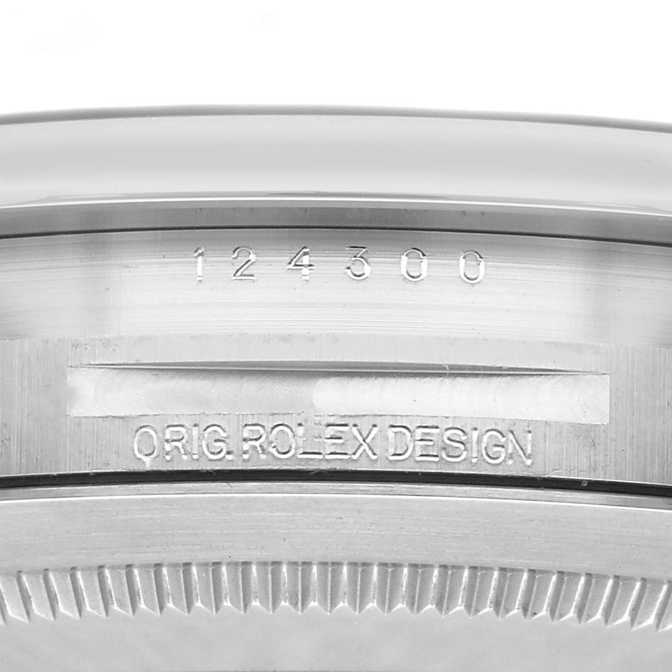 The image shows the side engraving of a Rolex Oyster Perpetual model 124300 with the model number and "ORIG ROLEX DESIGN" visible.