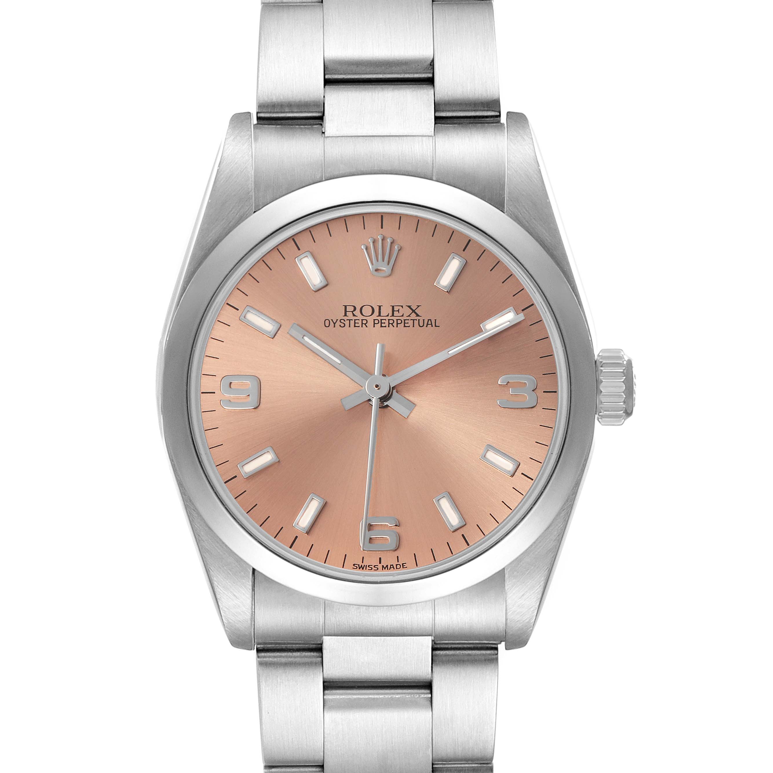 The Rolex Oyster Perpetual model 67480 watch is shown from a front view, highlighting its salmon dial, stainless steel bezel, and bracelet.