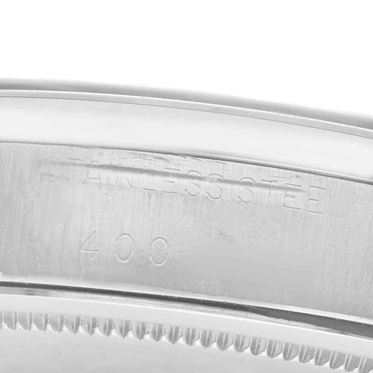 The image shows a close-up of the case side of a Rolex Date model, model number 6694, highlighting the "STAINLESS STEEL" engraving.