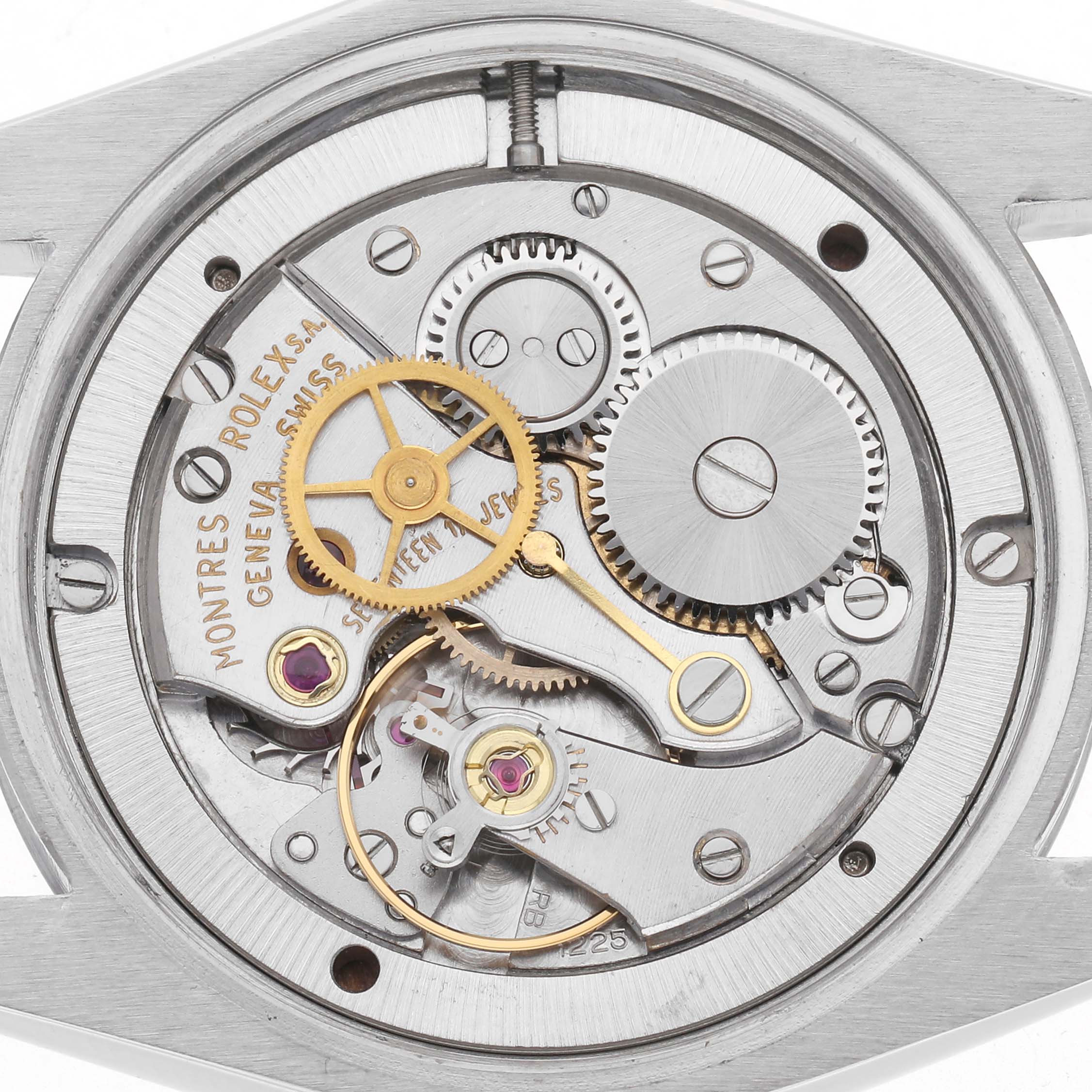 The image shows the movement of a Rolex Date watch, model 6694, focusing on the gears and mechanics from a top-down angle.