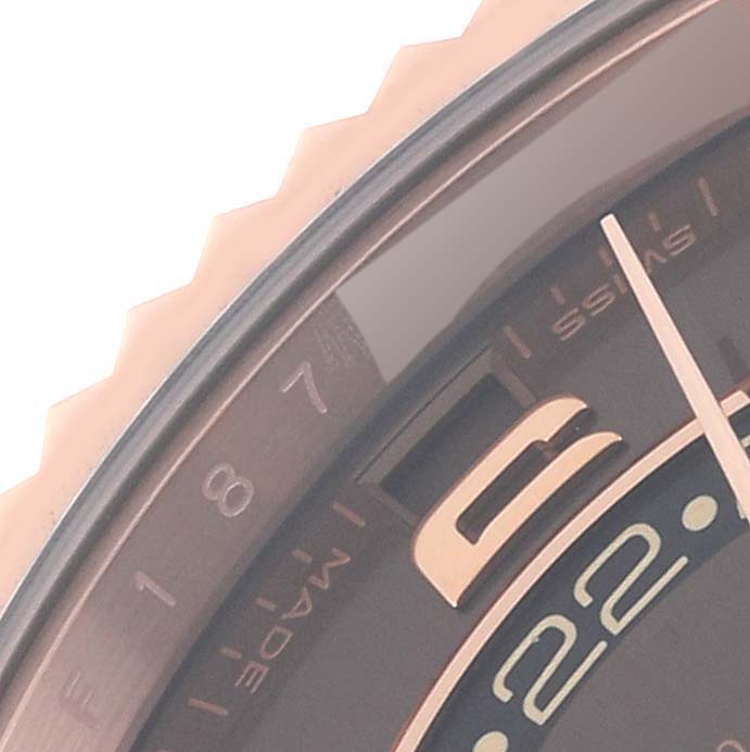 This close-up image shows a portion of the dial and bezel of the Rolex Sky-Dweller 326135 Men's Rose Gold Brown Dial 326135 Men's Rose Gold Brown Dial watch.